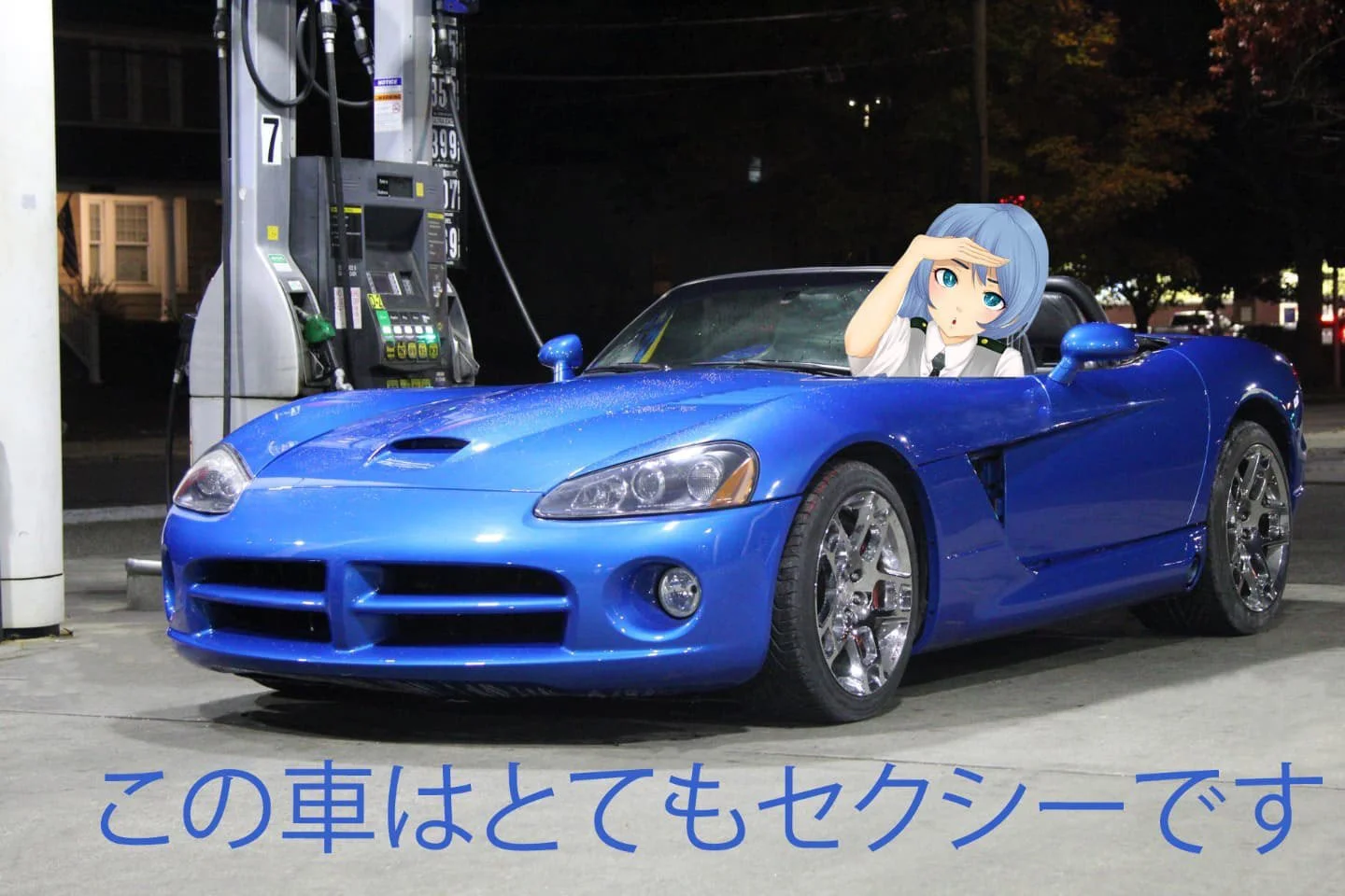 A blue sports car parked at a gas station at night, with a cartoon anime-style girl giving a salute from inside the car. The girl has blue hair and blue eyes, and is wearing a white shirt with a black tie. The image also contains Japanese text at the