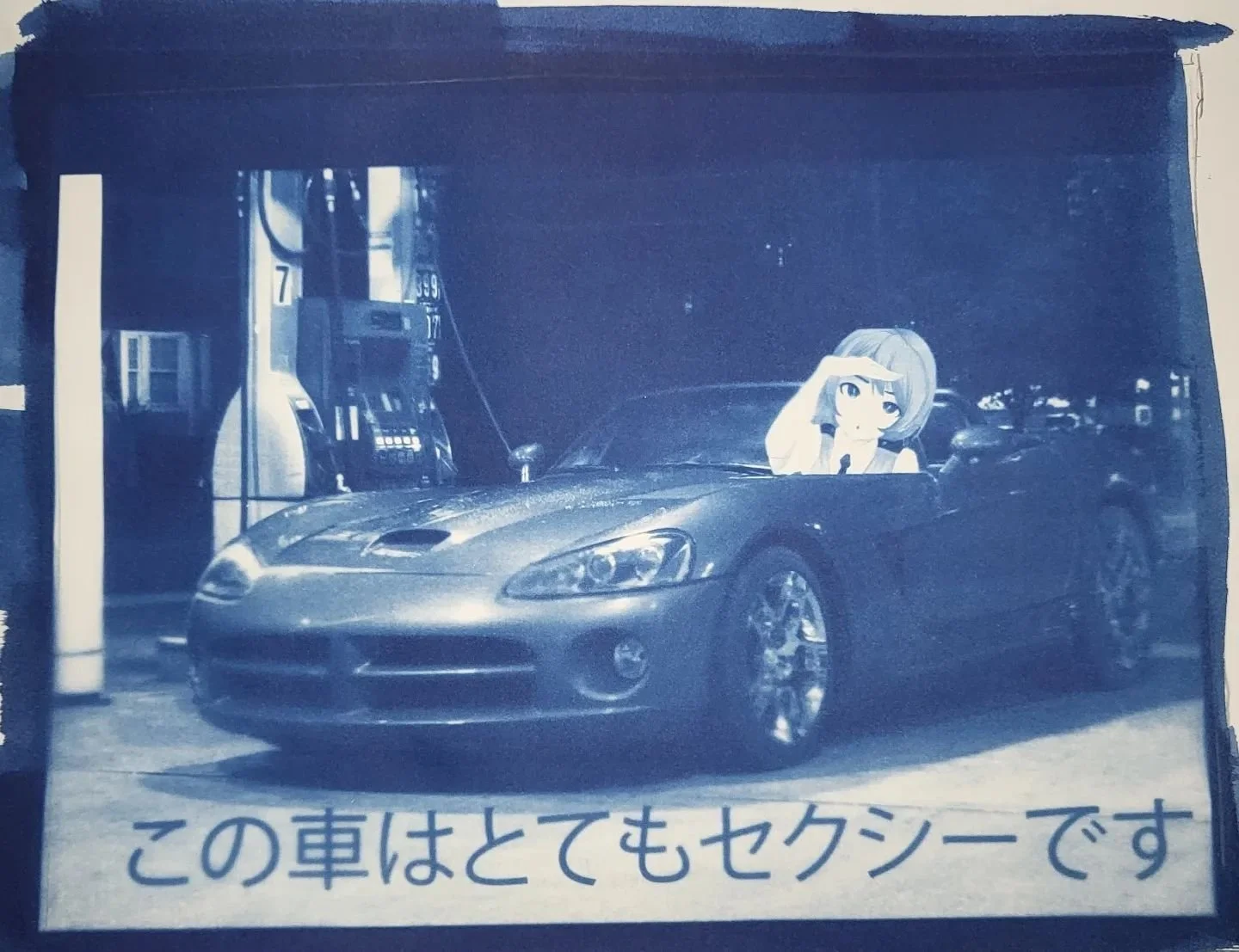A gas station with multiple fuel pumps and a sports car parked in front. A cartoon anime-style girl with short hair and a surprised or excited expression is sitting in the driver's seat, looking out the windshield. Japanese text at the bottom of the 