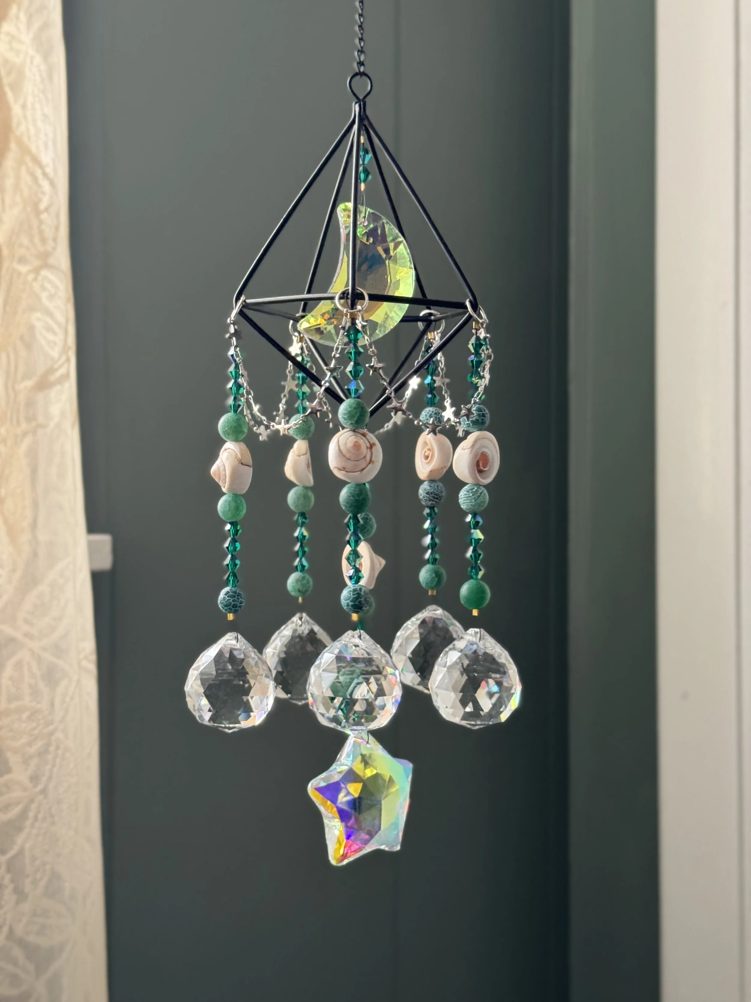 Hanging decorative sun catcher with beads, shells, and crystal prisms