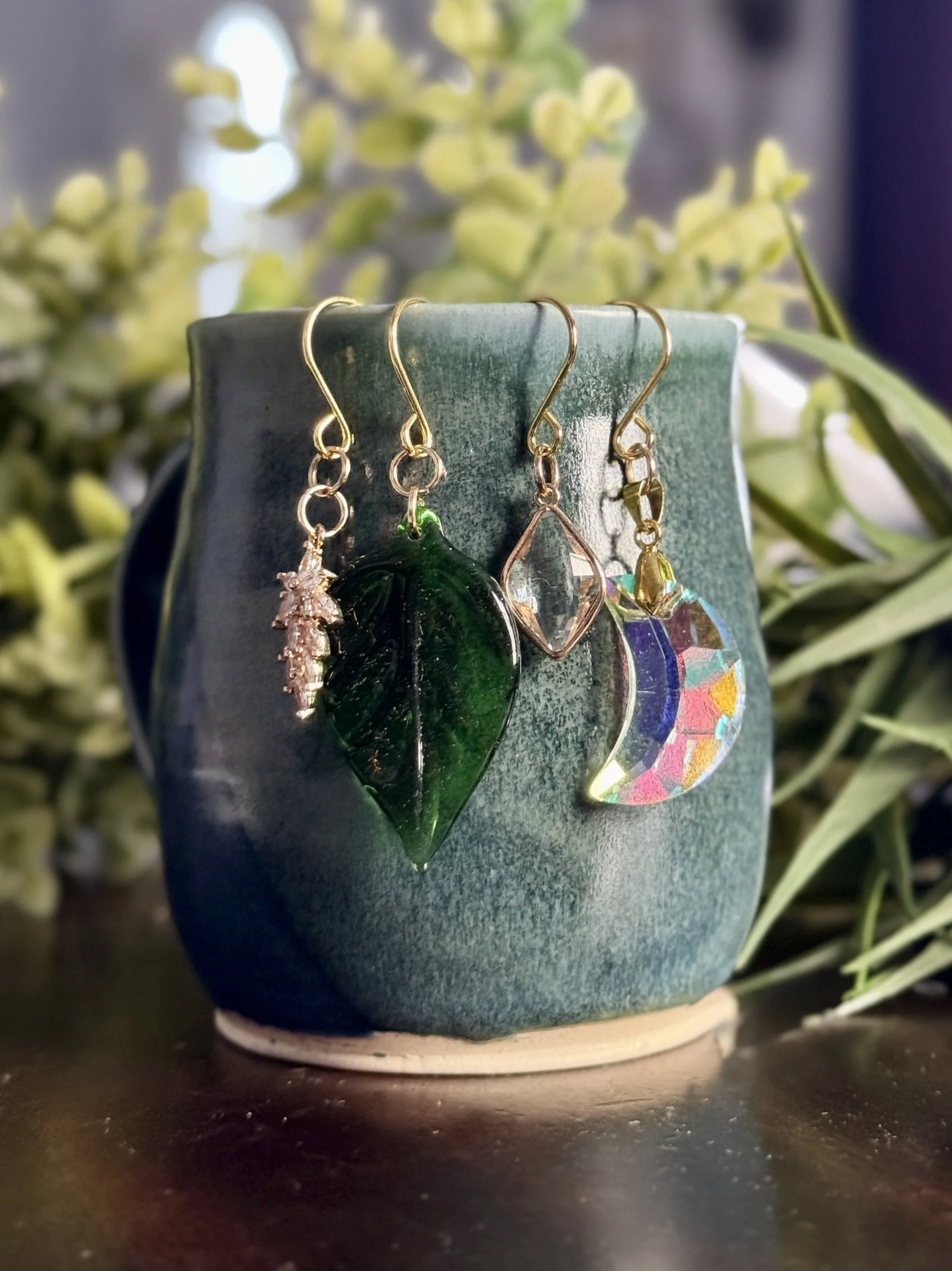 5th Front View of Crystal moon + antique glass leaf + 2 crystal pendant plant charms of a mug with leafy background