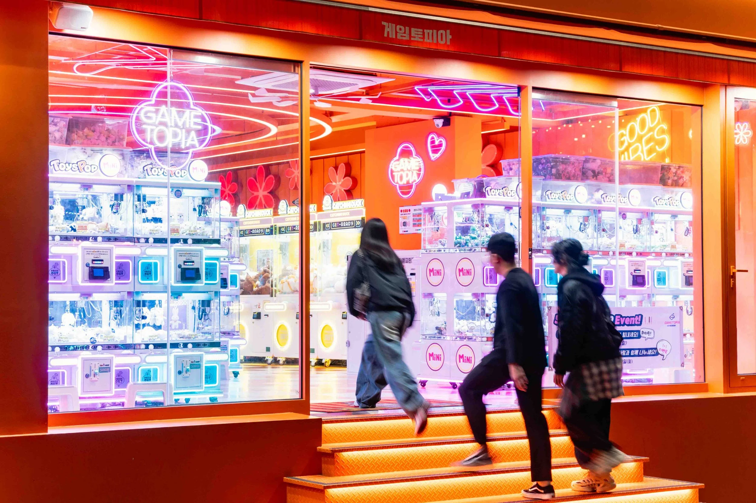 A women running into an orange lightened arcade store in Hongdae, Seoul. 