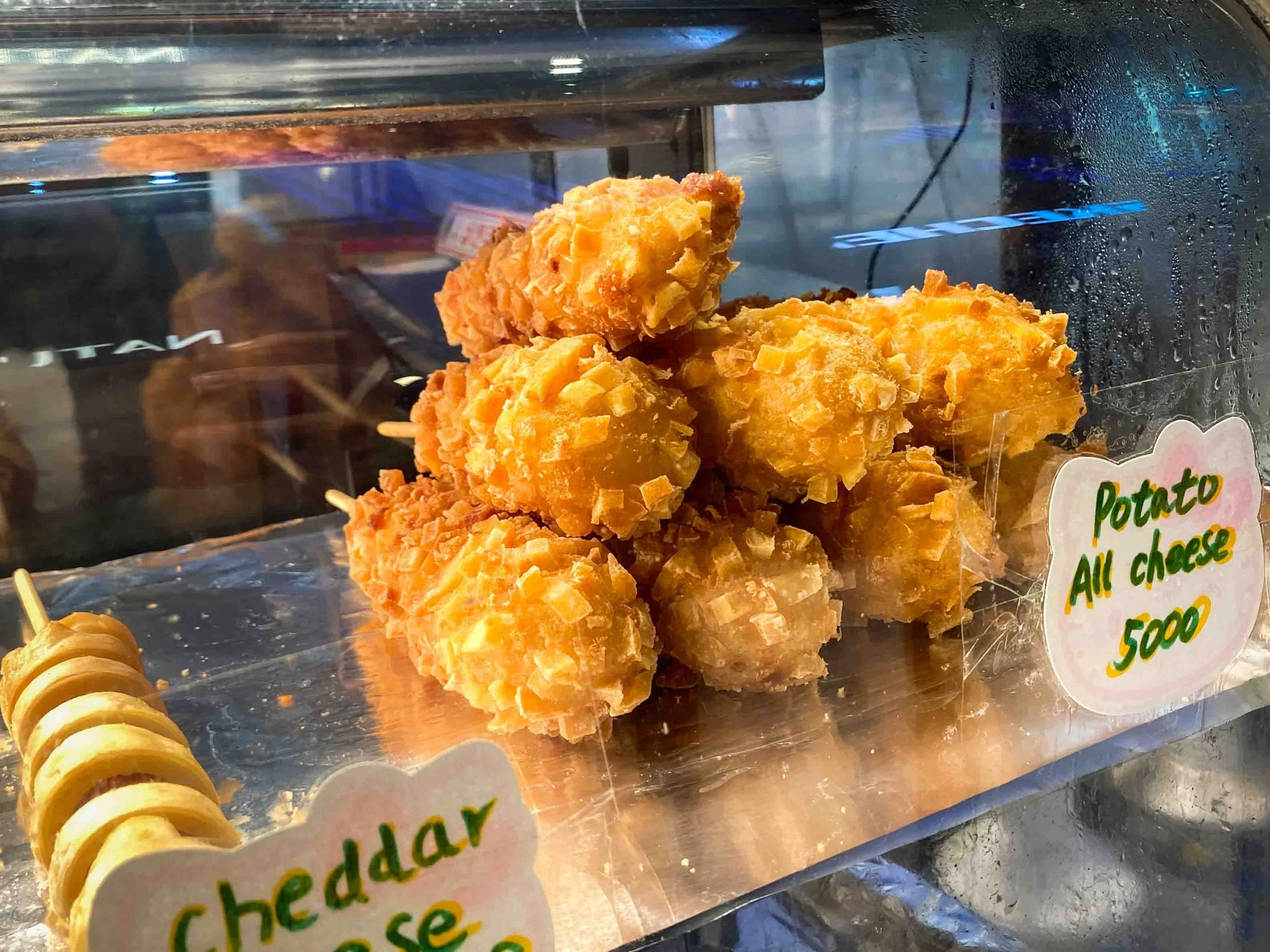  Eight potato fried Korean hot dogs showcased in a window of a street vendor in Gwangjang market in Seoul 