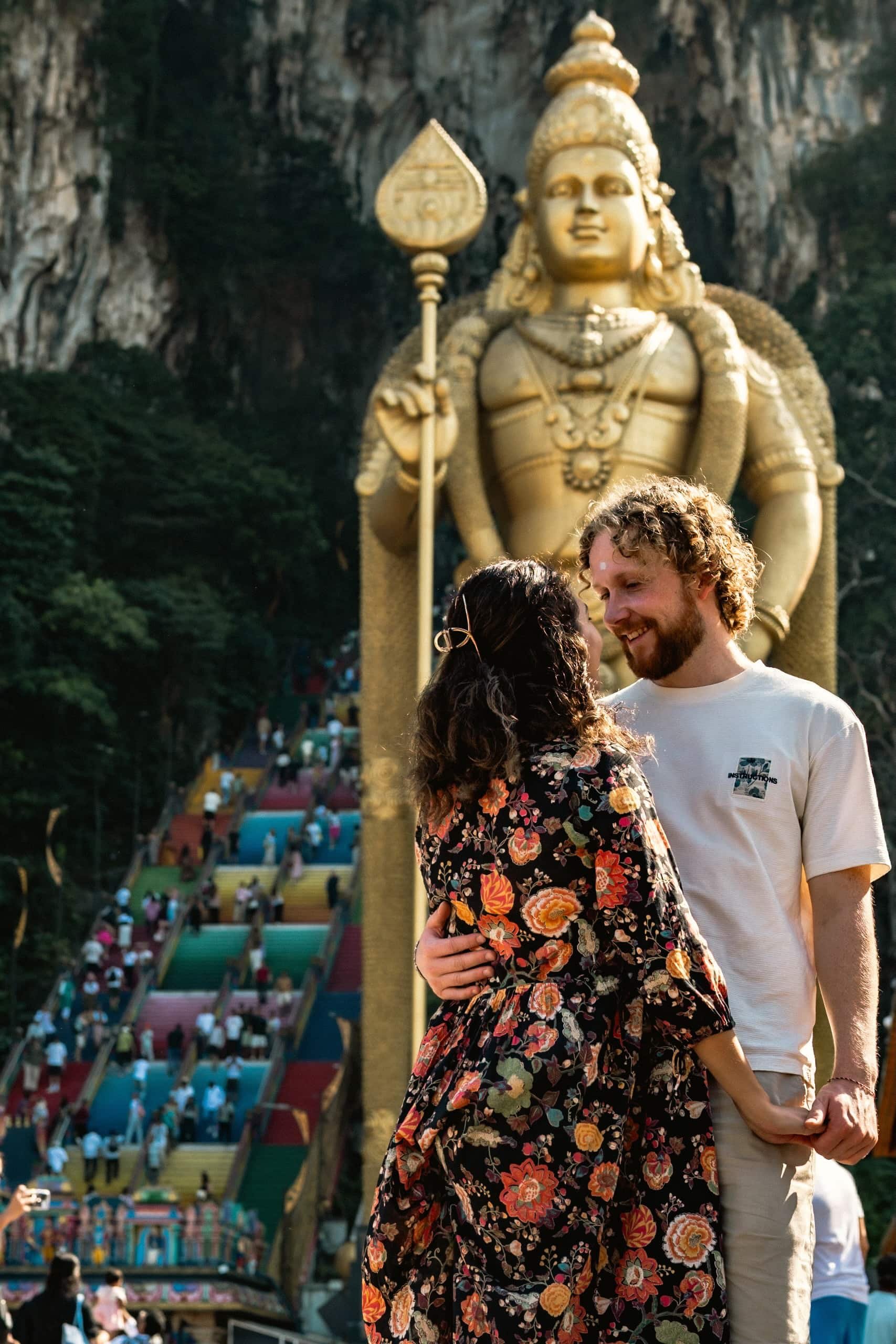  A travel couple posing in front of the lord Murugan statue