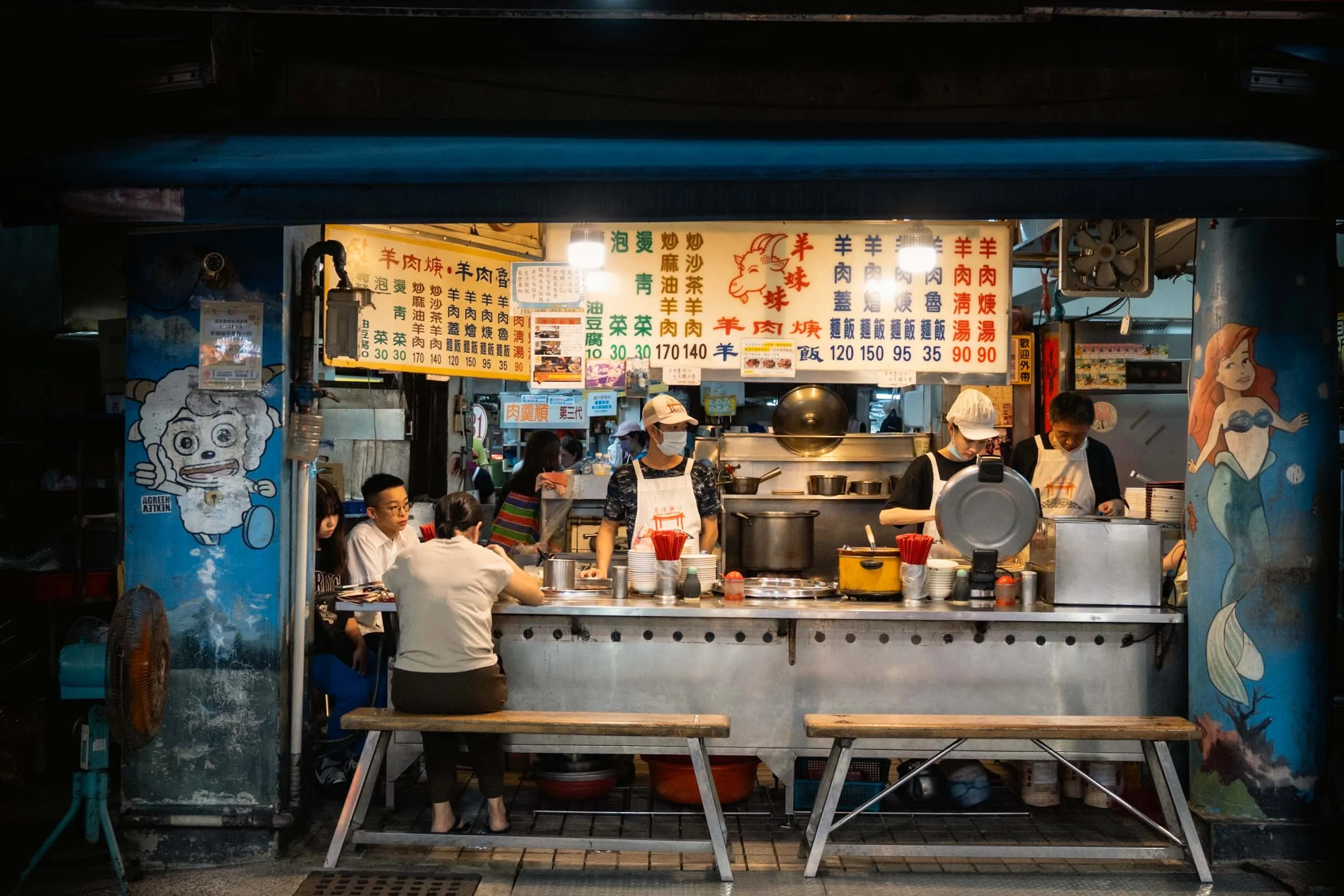 Woman eating at the street food seafood night market in keelung taiwan and sellers can also be seen