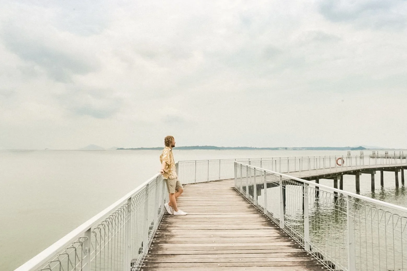 Traveler walking along the Pulau Ubin coastal trail with sea views and tropical greenery