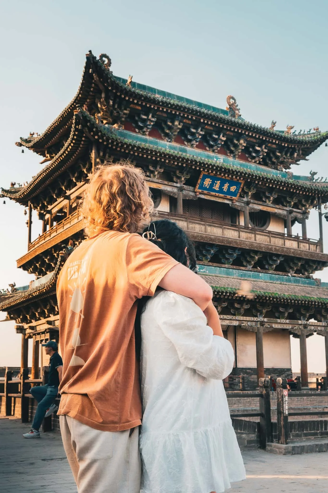 traveler couple hugging taking picture in front of the south gate in the iconic touristic spot in pingyao china