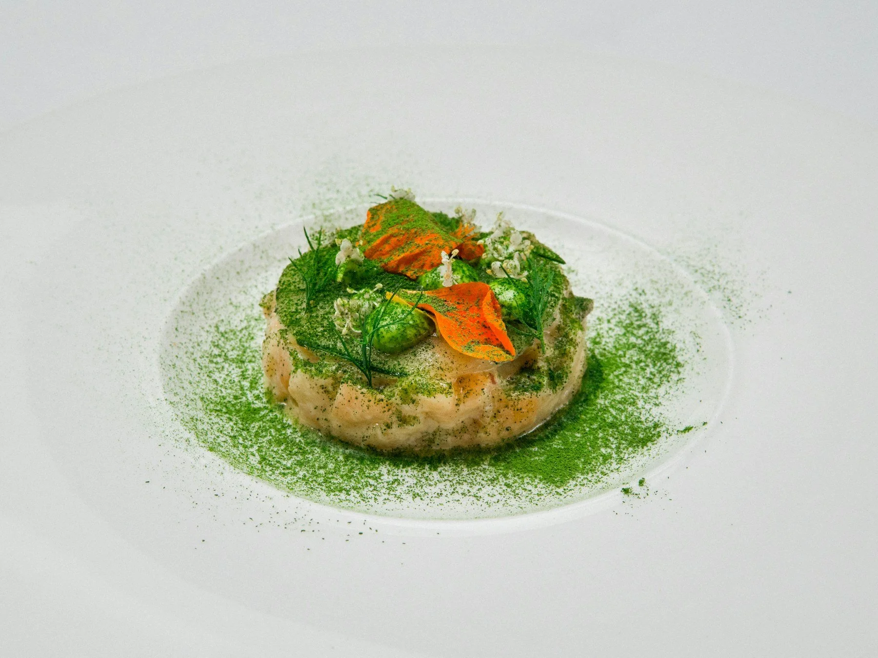 Plated green vegetable dish on white ceramic