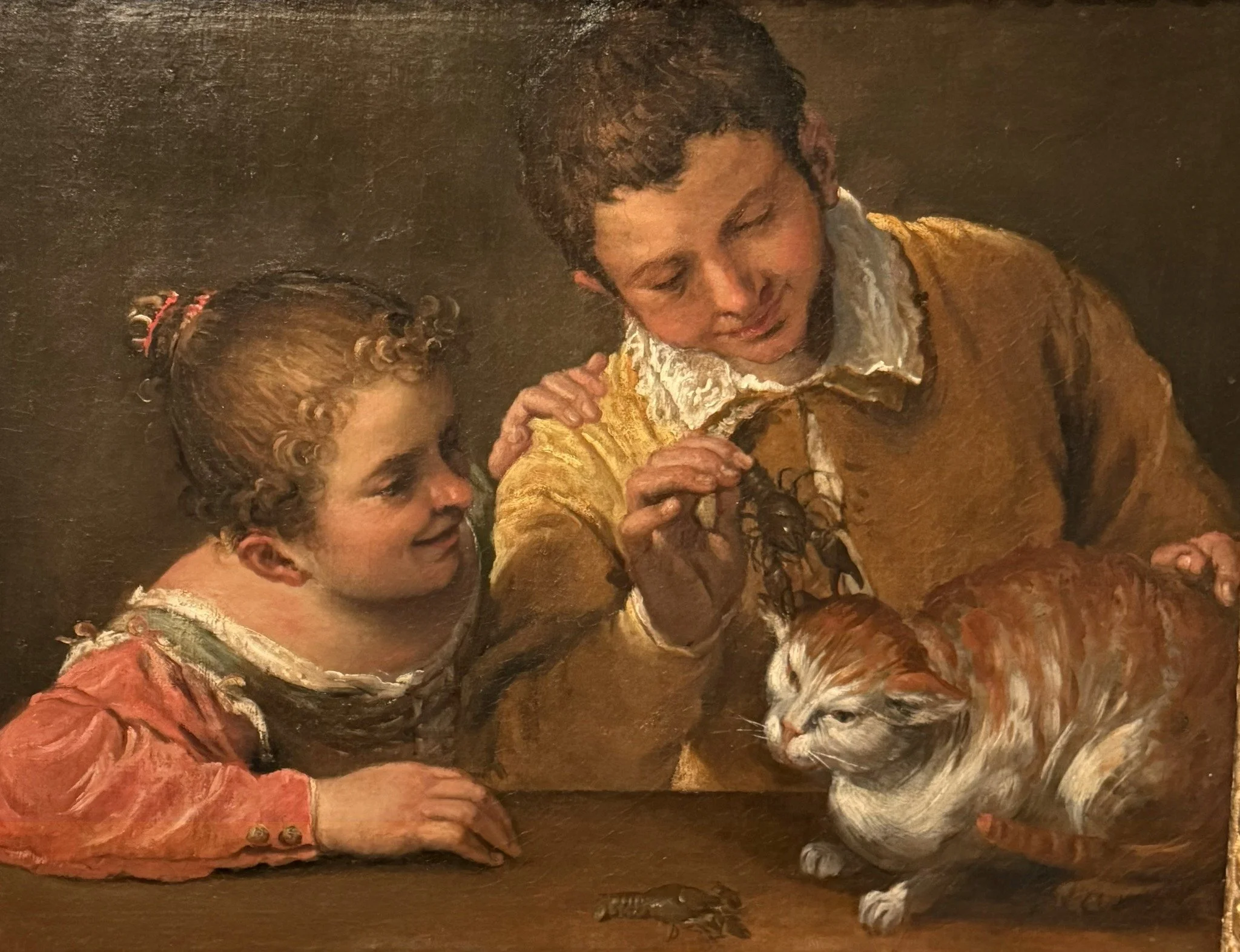 Two Children Teasing a Cat (c.1587) Annibale Caracci.  In this lively genre scene, Annibale Carracci captures a mischievous moment as two children play with a clearly irritated cat. A crayfish clamps onto the cat&rsquo;s ear, adding to its distress, 