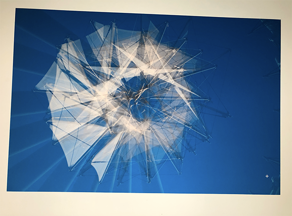 Abstract digital artwork featuring a three-dimensional geometric shape with interconnected transparent and white triangular facets on a blue background.