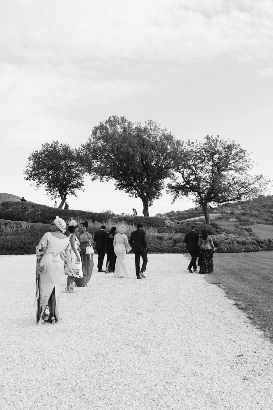 Wedding guests drift through the Tuscan countryside in a quiet, cinematic moment. A timeless perspective on a Villa Cetinale destination wedding, rooted in connection and atmosphere