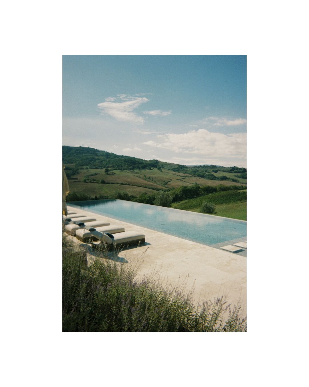 Infinity pool overlooking the Tuscan countryside at Podere Tesoro, Tuscany wedding venue captured on 35mm film, with soft summer light and natural serenity
