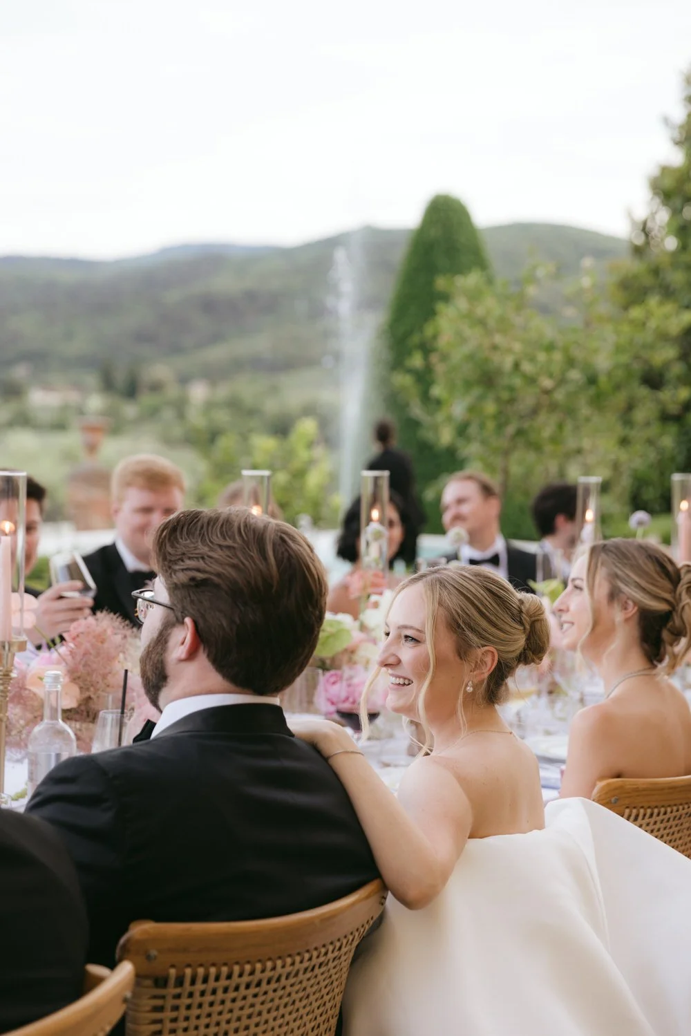 Bride seated at a dinner table, smiling during the reception at a Palagina Tuscany wedding