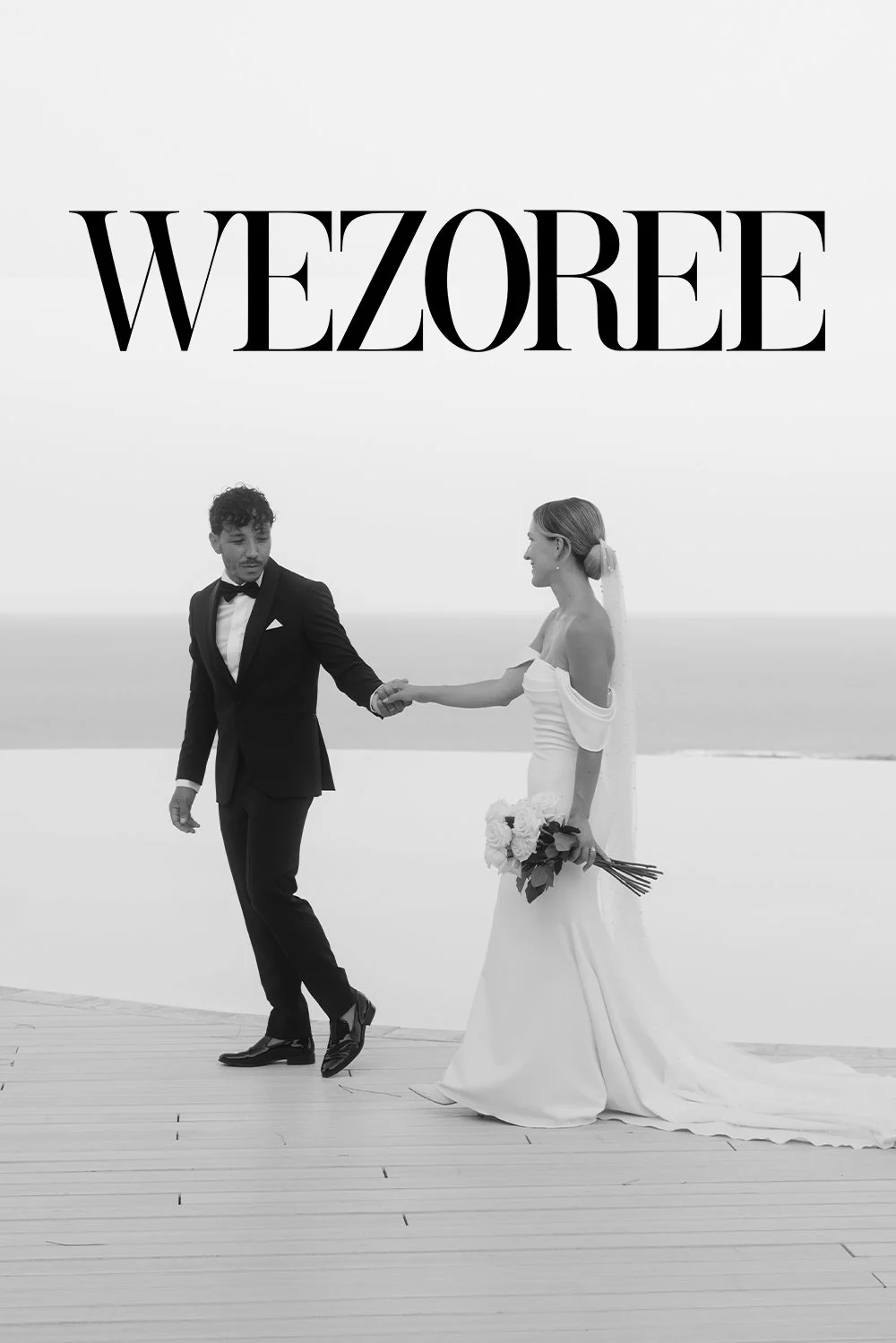 Elegant bride and groom walking hand in hand at Villa Mon Repos in Taormina, Sicily. Captured in a timeless black-and-white portrait overlooking the Mediterranean Sea, featured on Wezoree