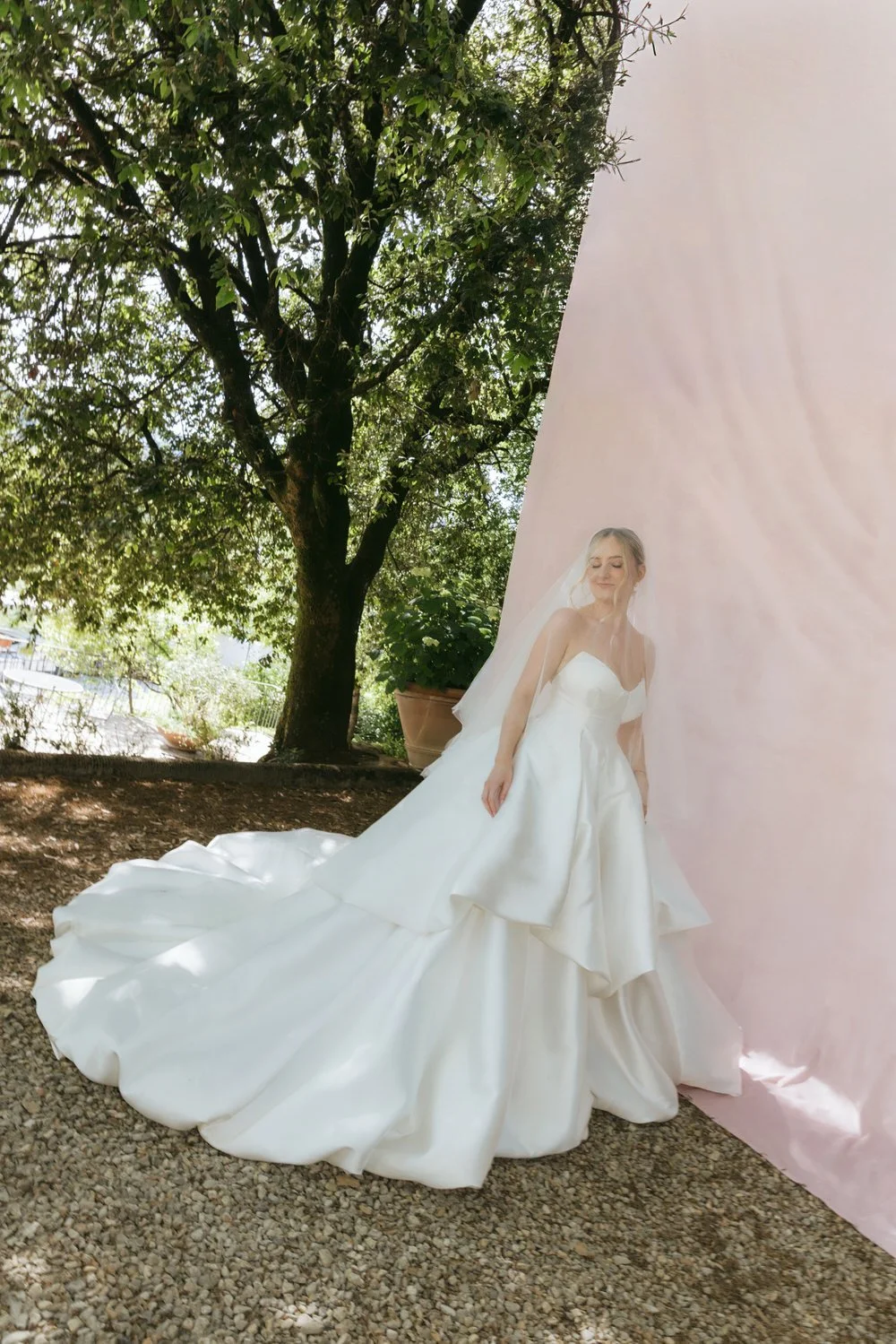 an editorial photo of the bride in sculptural steven khalil gown at her palagina tuscany wedding against a soft blush editorial backdrop