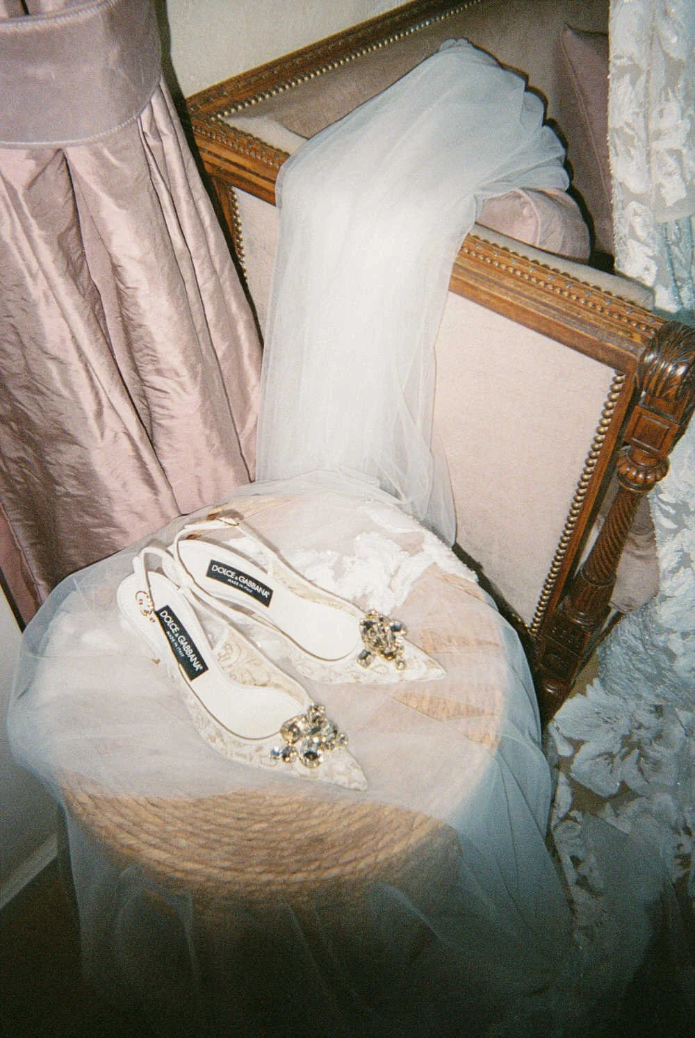 Delicate Dolce & Gabbana bride heels and soft veil rest in quiet anticipation, capturing the essence of bridal preparation. A refined La Foce wedding detail with timeless elegance in Tuscany 