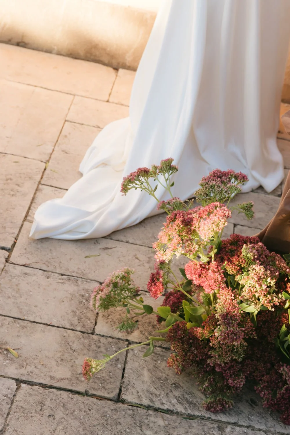 Elegant floral design with deep pink and burgundy and green flowers at a sunset braccialieri sicily wedding