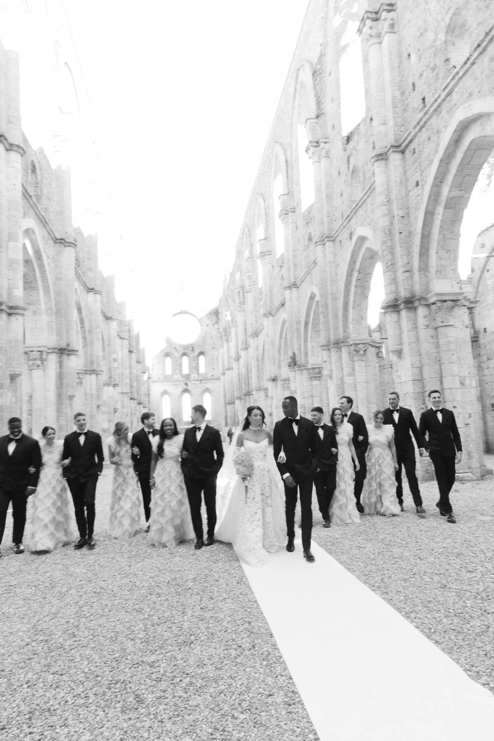 A refined bridal party walks through the iconic San Galgano Abbey, blending movement, architecture, and timeless emotion. A powerful editorial moment from a Tuscany destination wedding