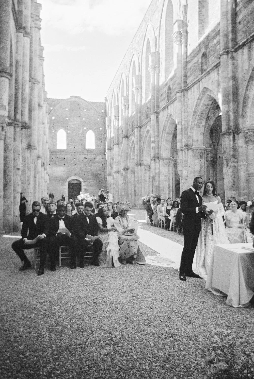 A cinematic black and white moment during vows inside San Galgano Abbey, where architecture and emotion merge. Timeless Tuscany wedding storytelling at its most intimate