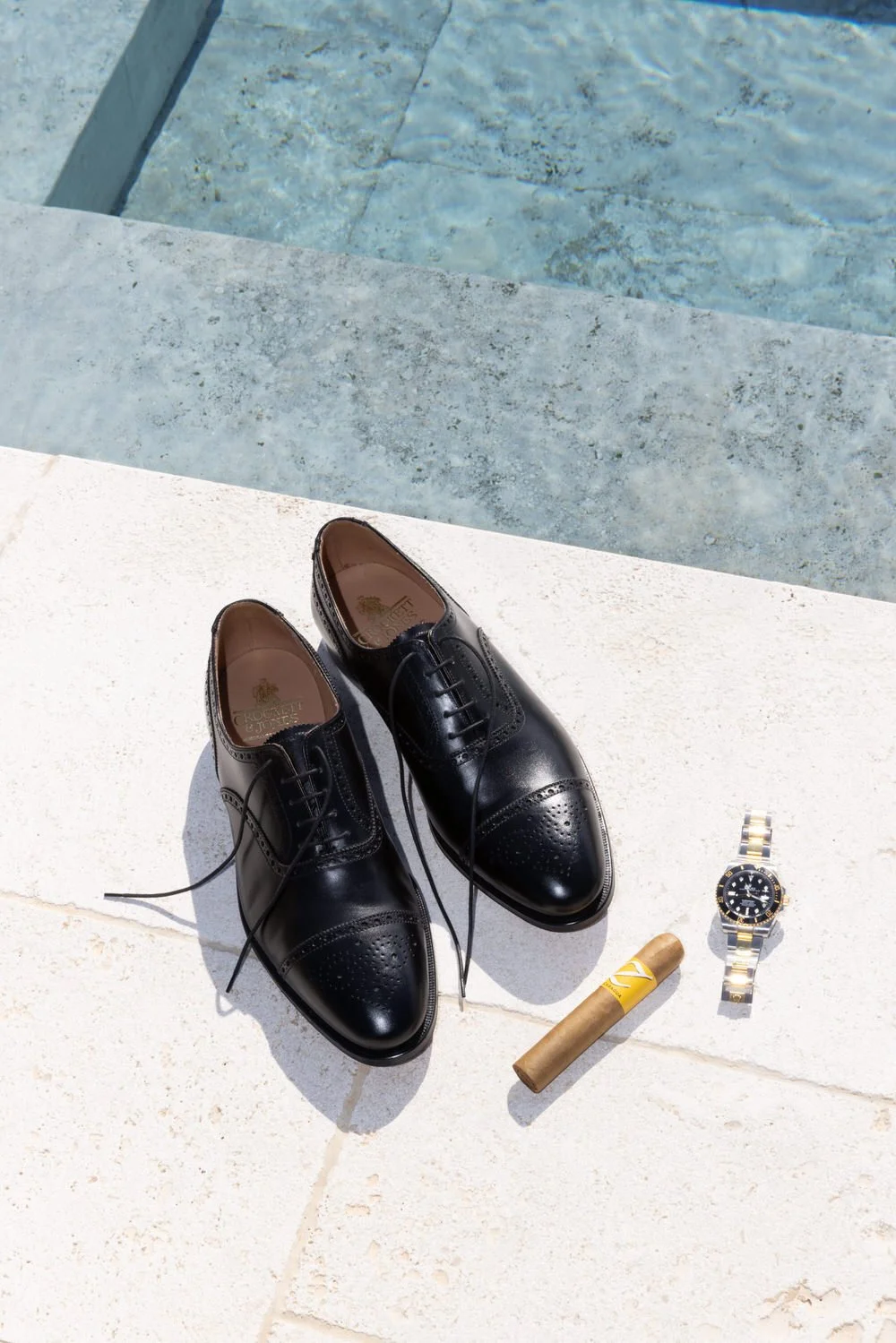 A curated flatlay of groom details by the pool, where texture and light meet understated luxury. A modern Tuscany wedding detail shot with editorial precision at villa san michele, Florence 
