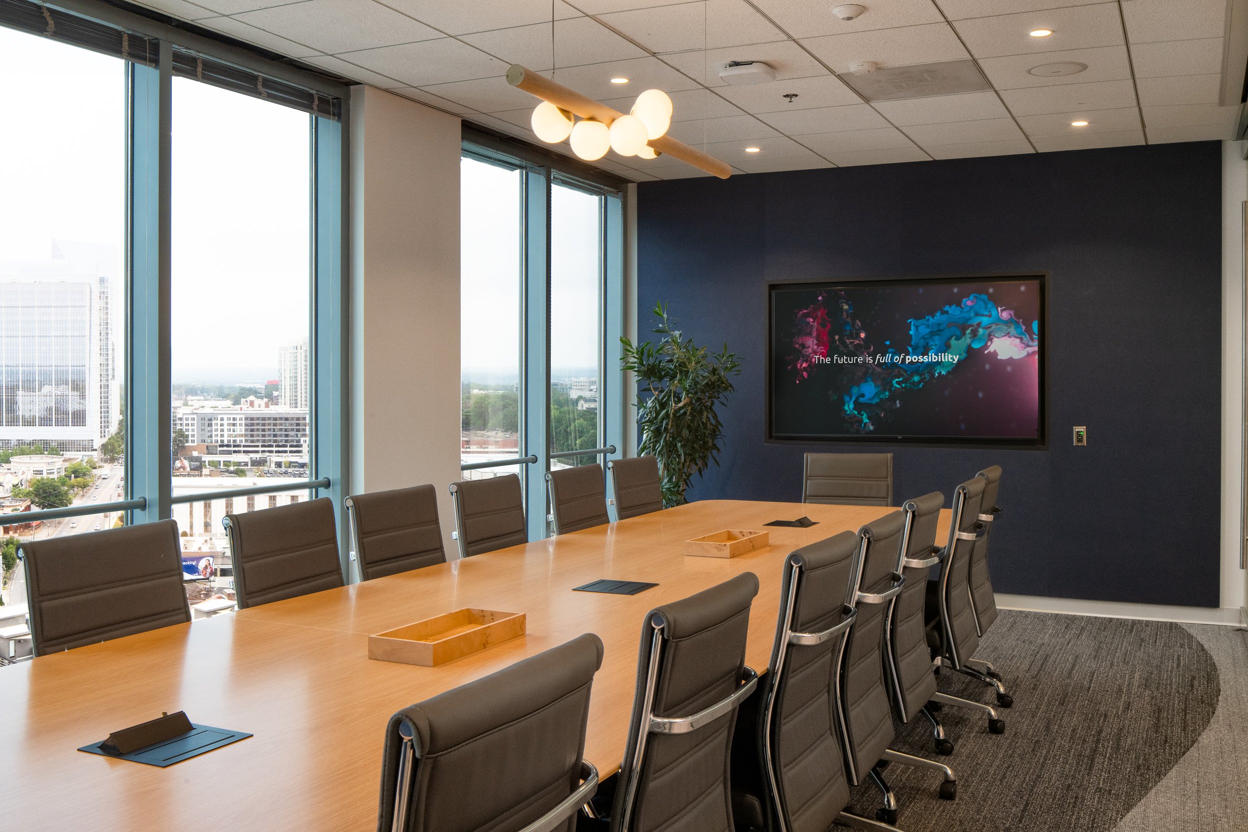 Modern corporate boardroom with large windows and sleek chairs.