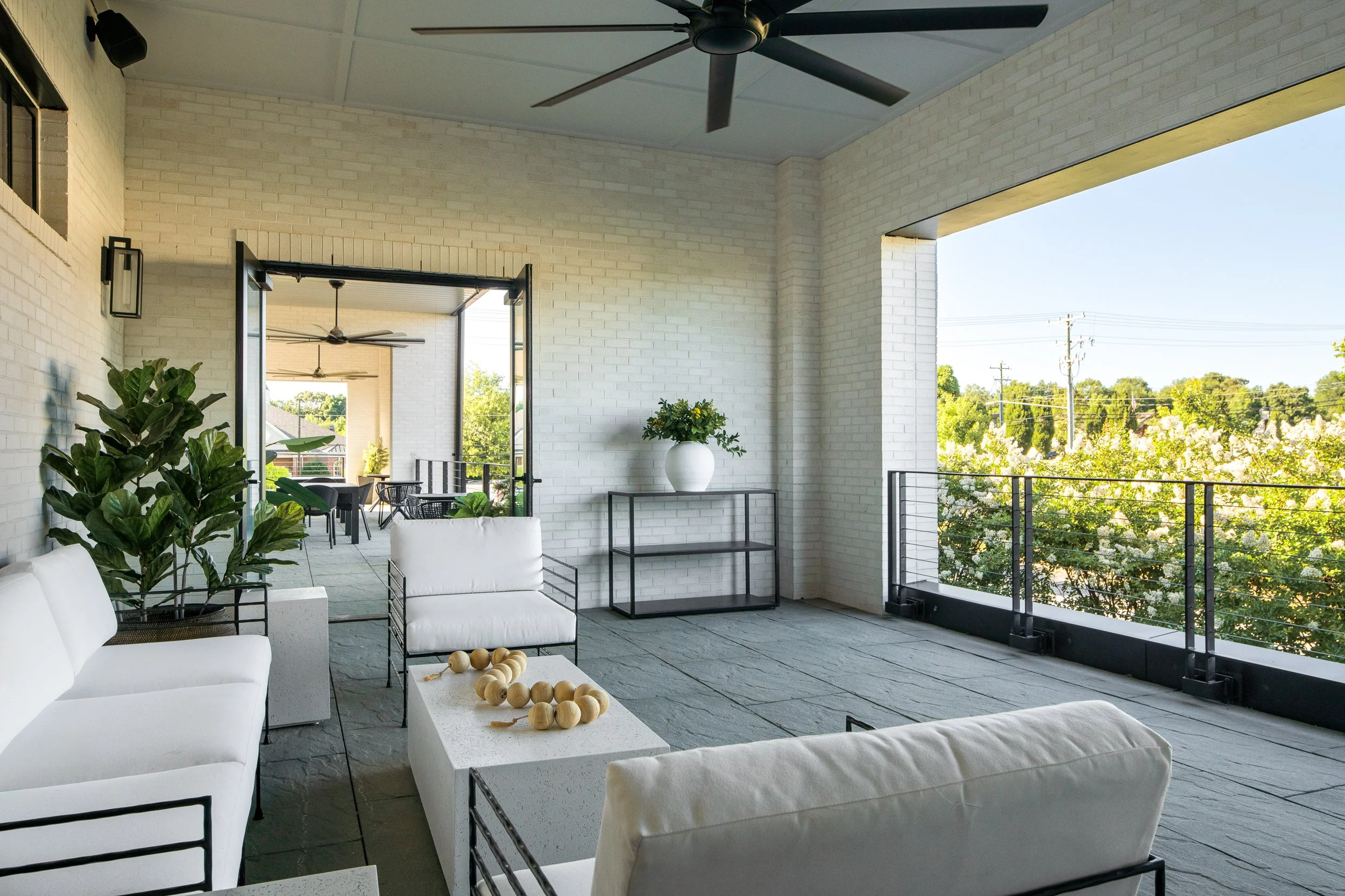 Elevated patio with modern seating and potted greenery.