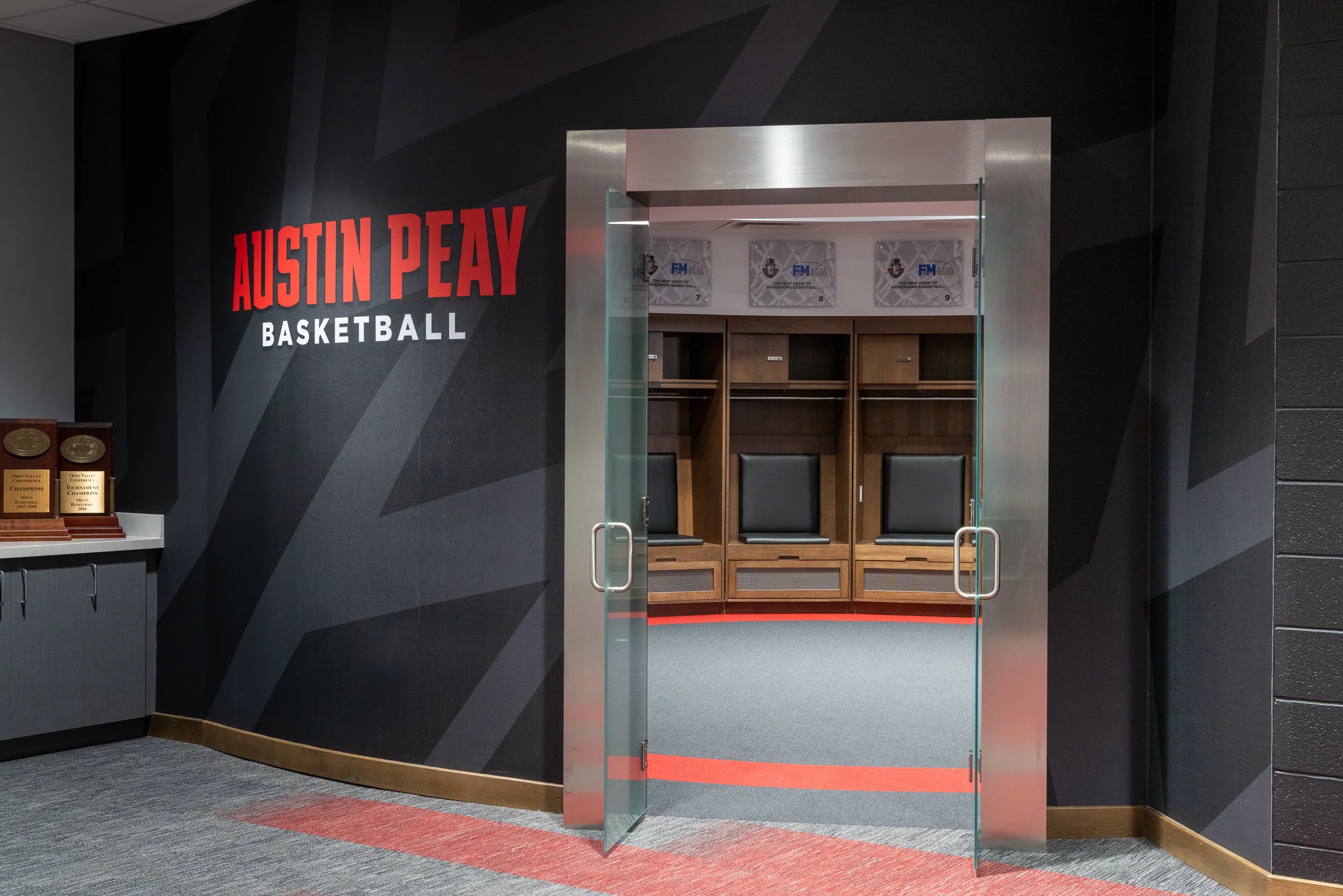 Modern locker room entrance featuring sleek glass doors and branding.