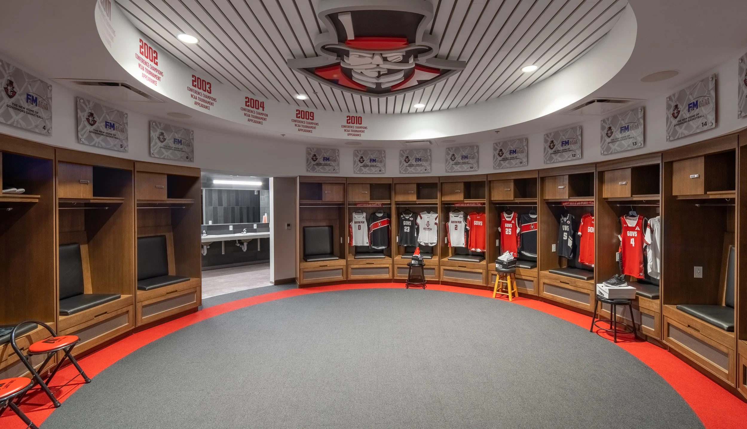 Round locker room featuring wood paneling and built-in seating.