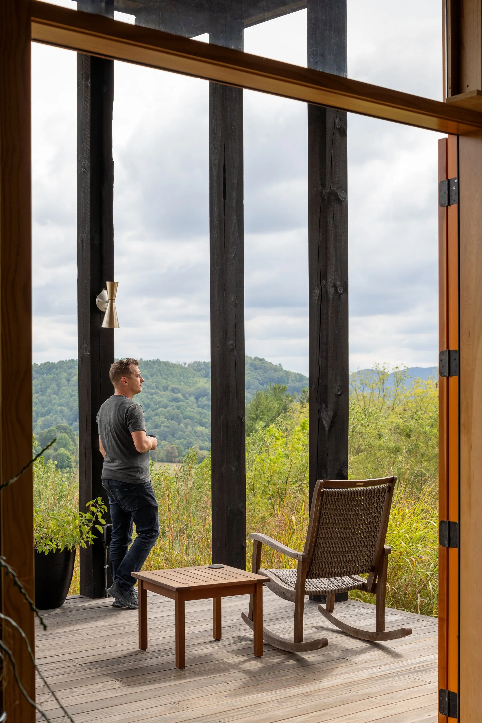 Covered porch with wooden rocking chairs overlooking mountain views.