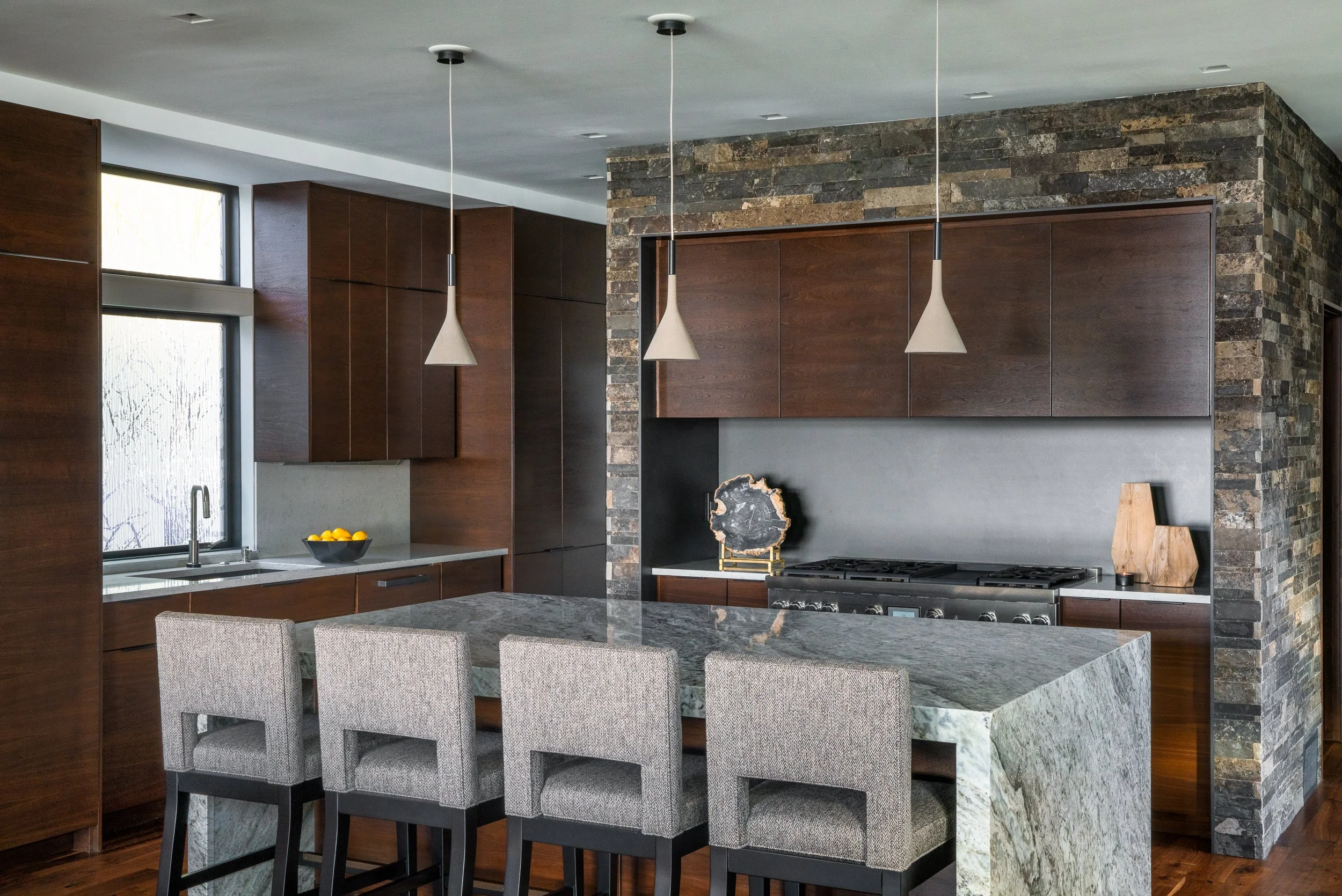 Kitchen island and dining area with stone and wood accents in a modern home.