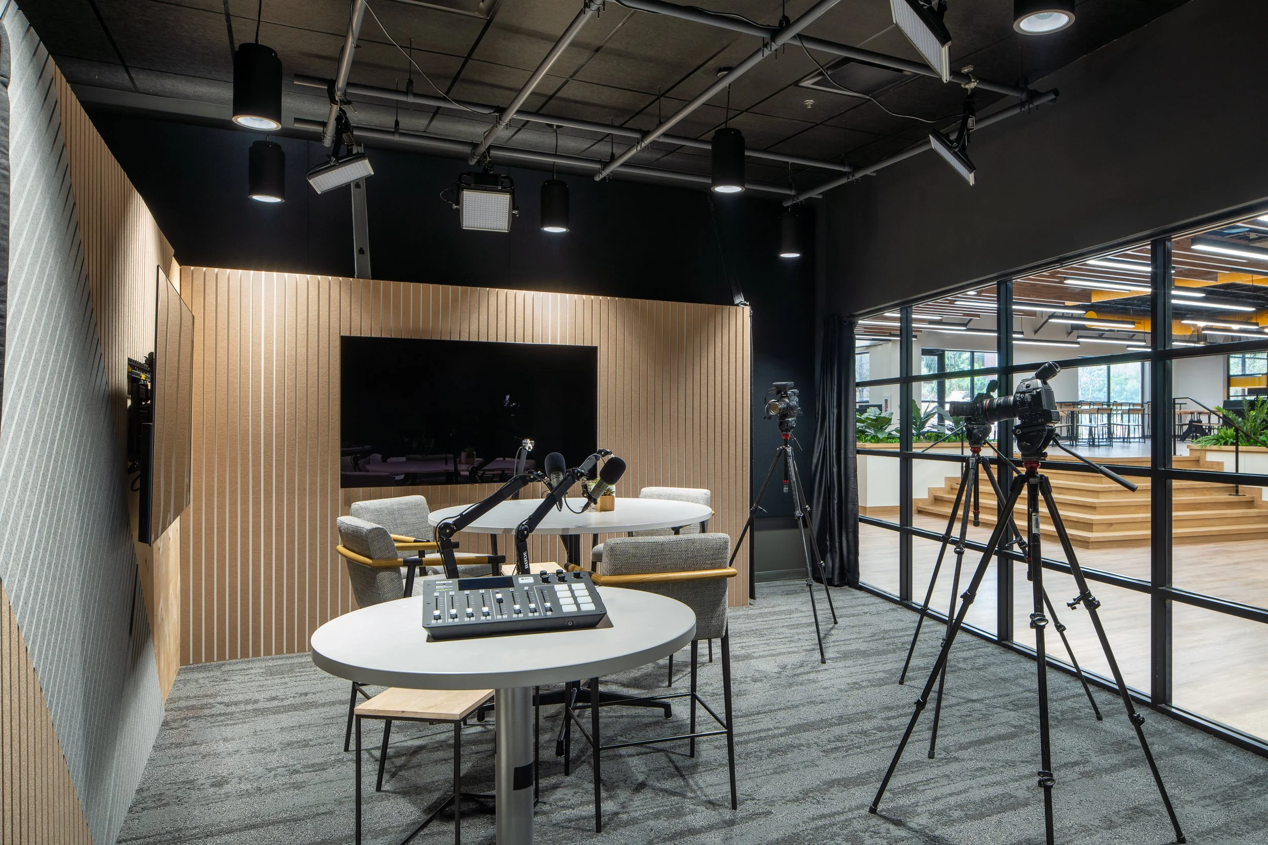 Professional podcast studio with recording equipment, cameras, and soundproofing.