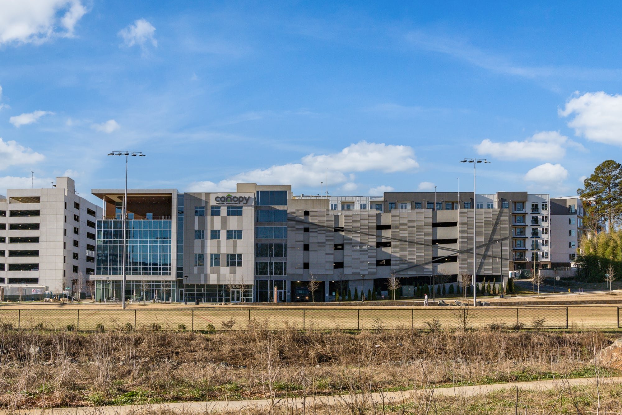 Exterior view office building and adjacent parking structure under a bright blue sky in Charlotte.