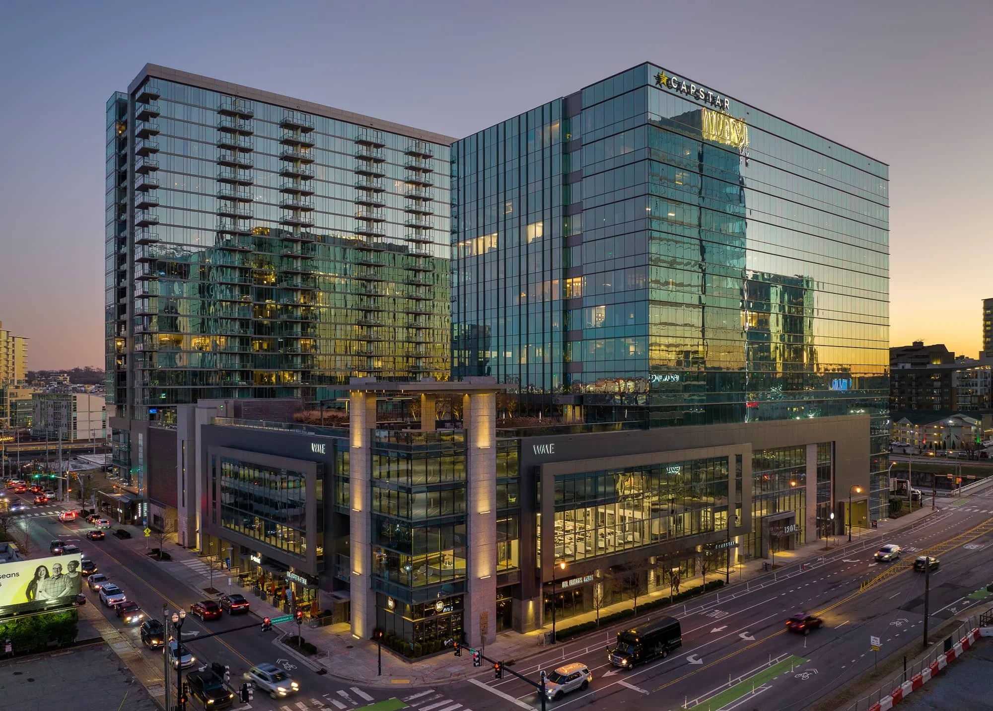 Aerial drone view of the CapStar Building in downtown Nashville at dusk with a gradient sky reflecting off the glass facade