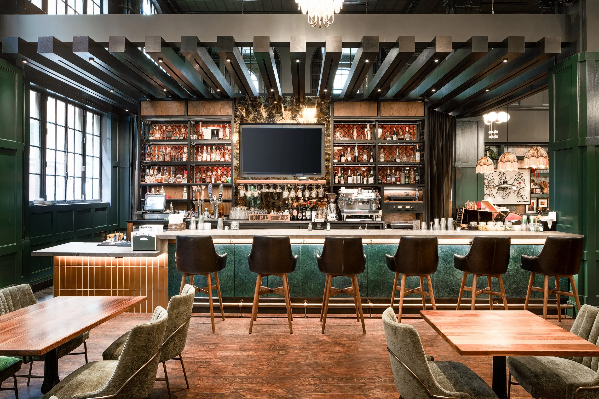 Luxury hotel bar interior with pendant chandeliers, rich wood paneling, and warm ambient bar lighting