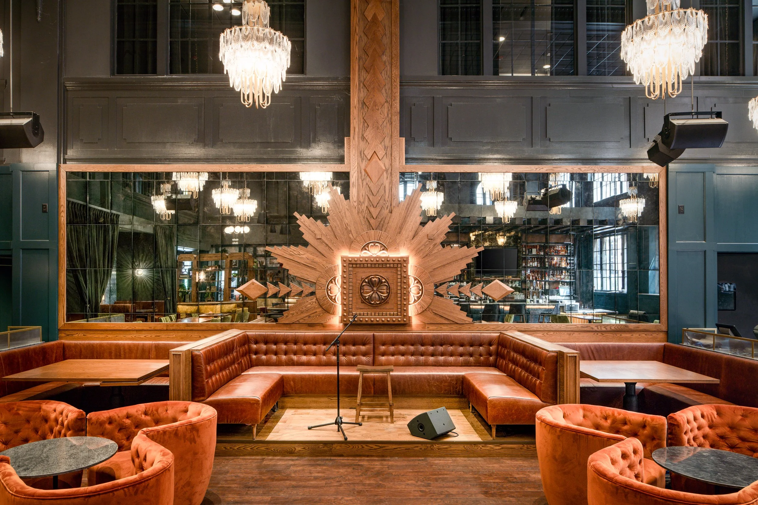 Decorative wall detail in a hotel lounge featuring layered wood panels and an ornate mirror