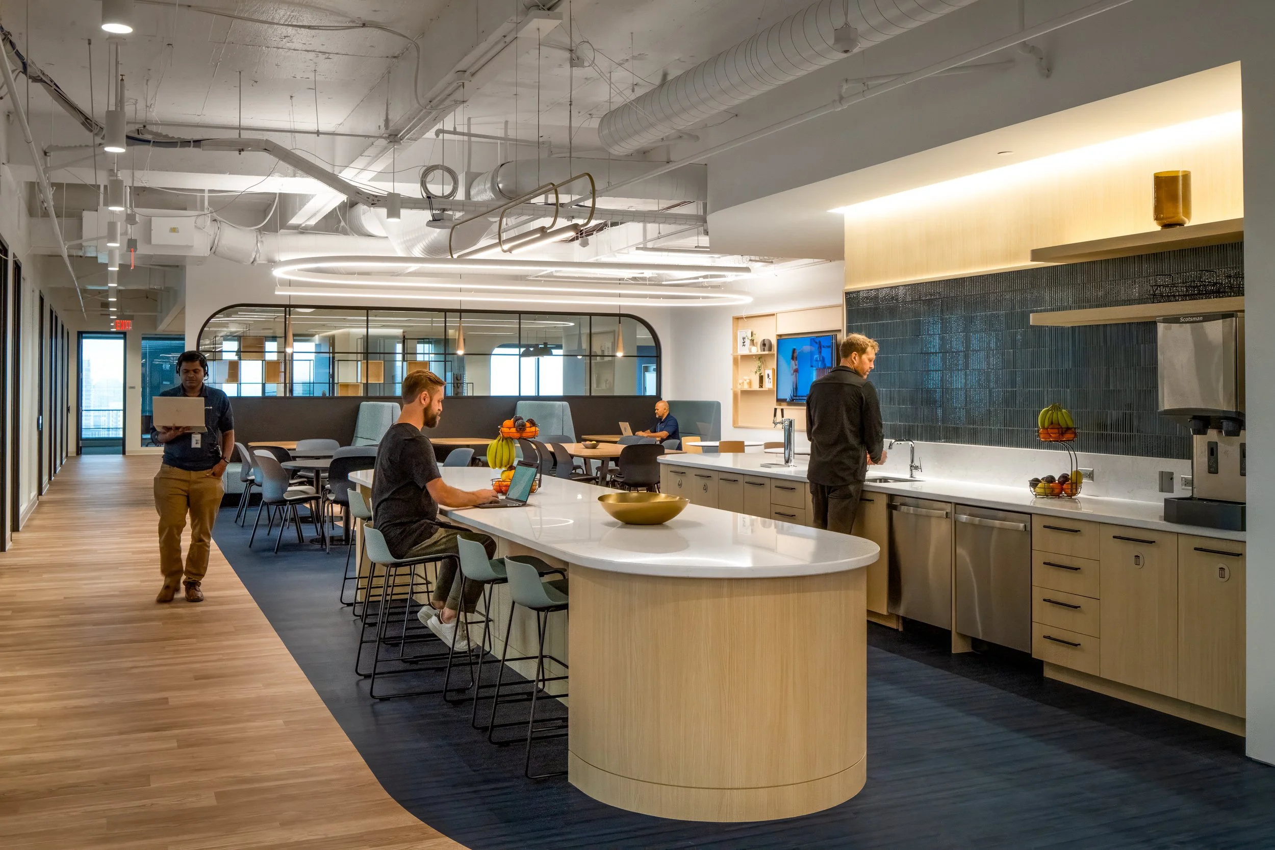 Open break room with large communal table and modern kitchen.