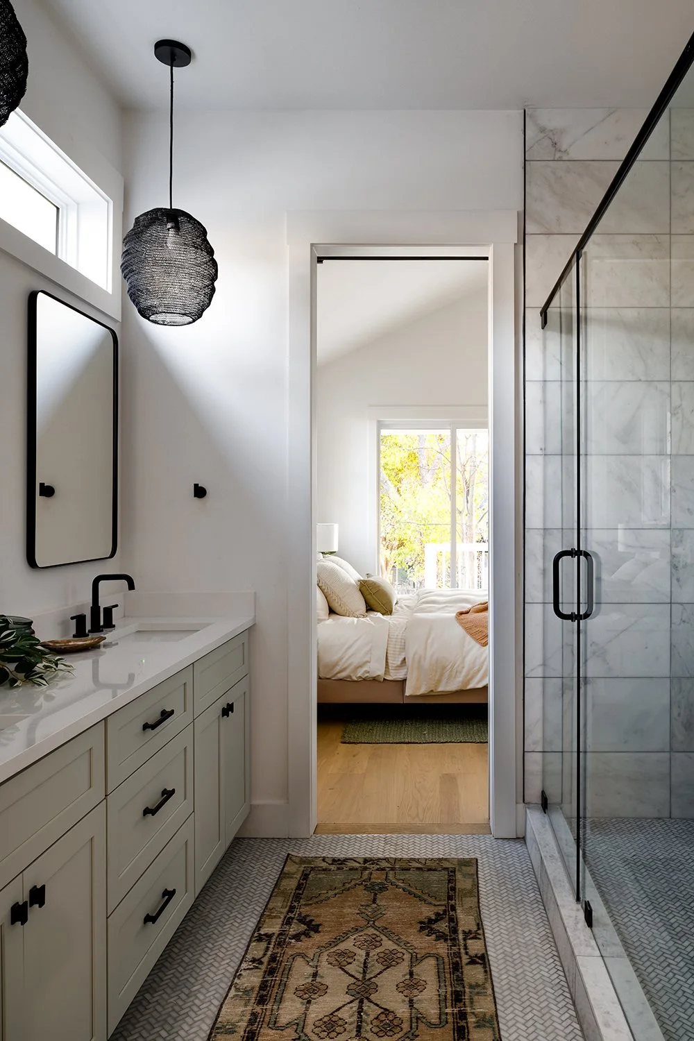 Master bathroom with spacious shower and bedroom view.