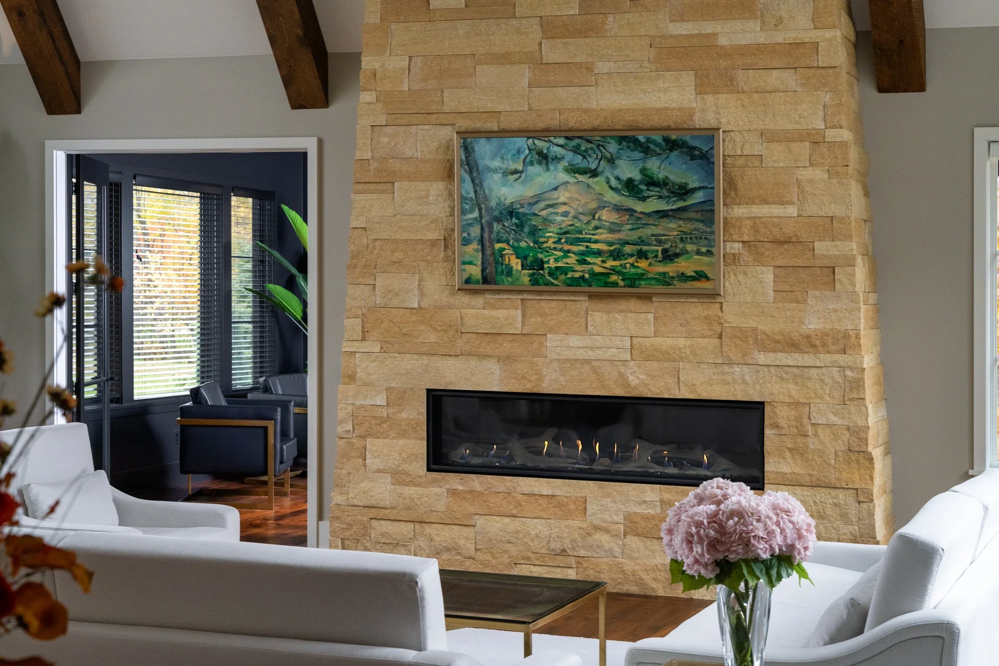Luxury living room with a stone fireplace and framed artwork.
