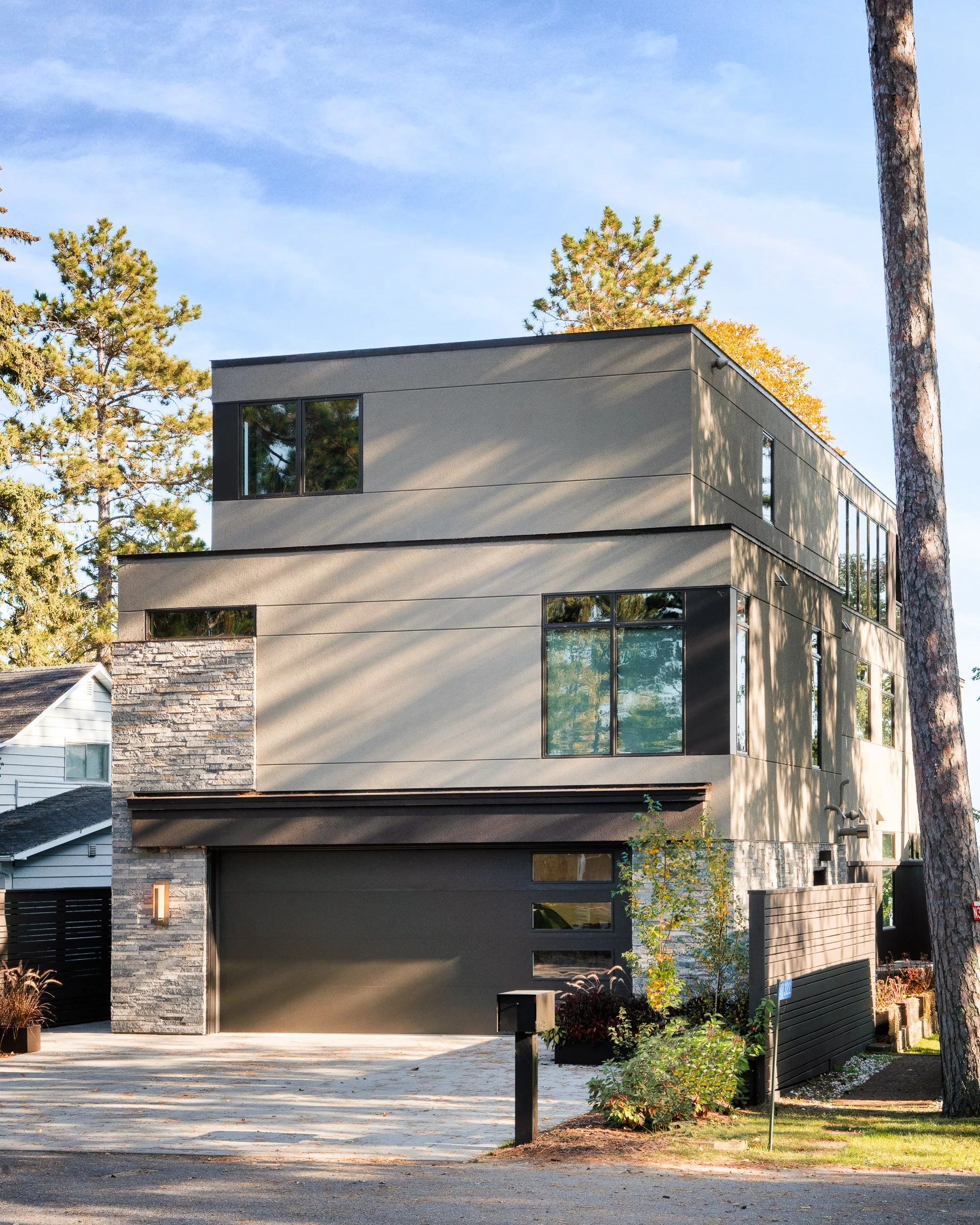 Side facade of a modern lake home with clean lines and natural materials.