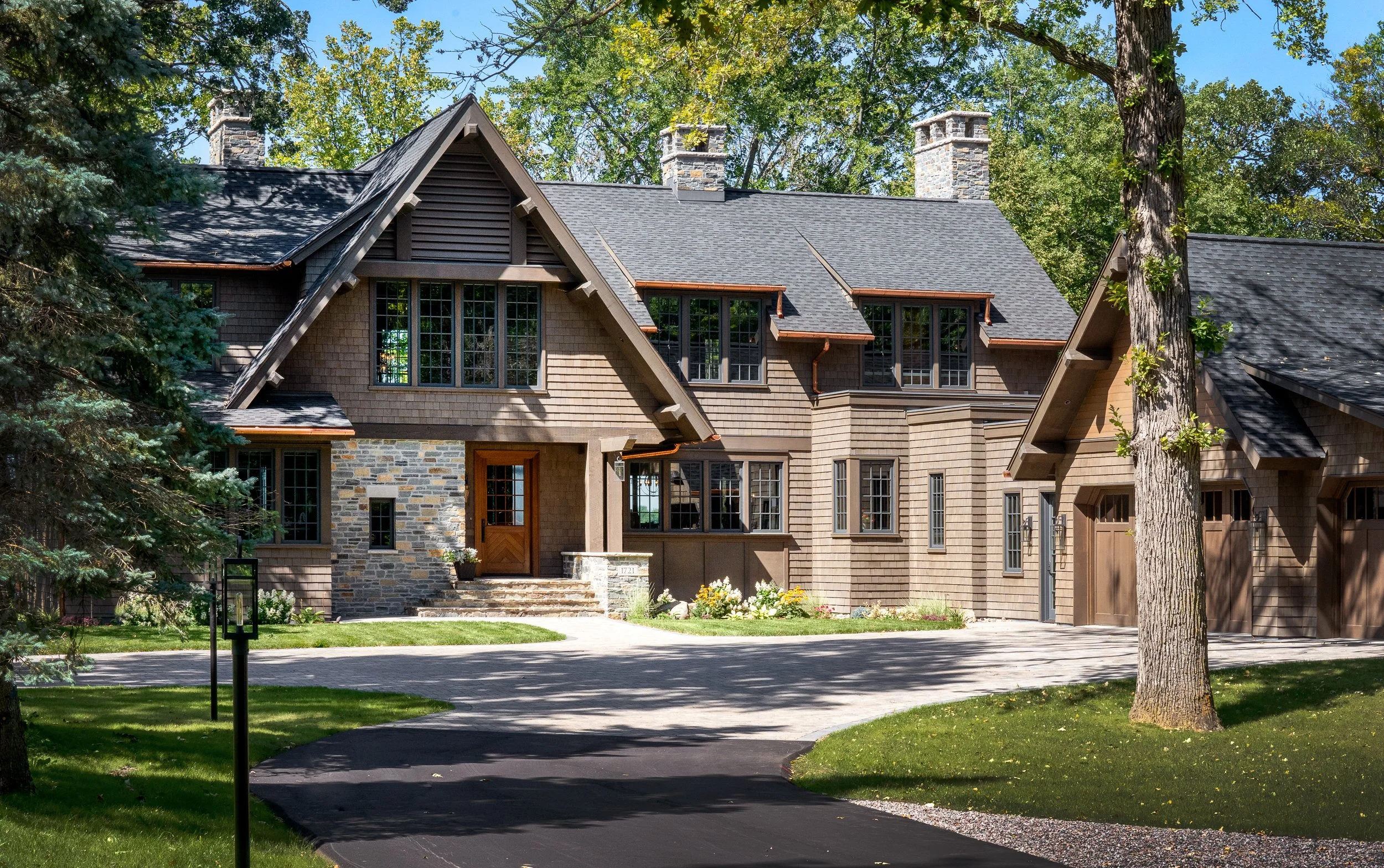 Detailed front view of modern home entryway with large windows and stone accents.