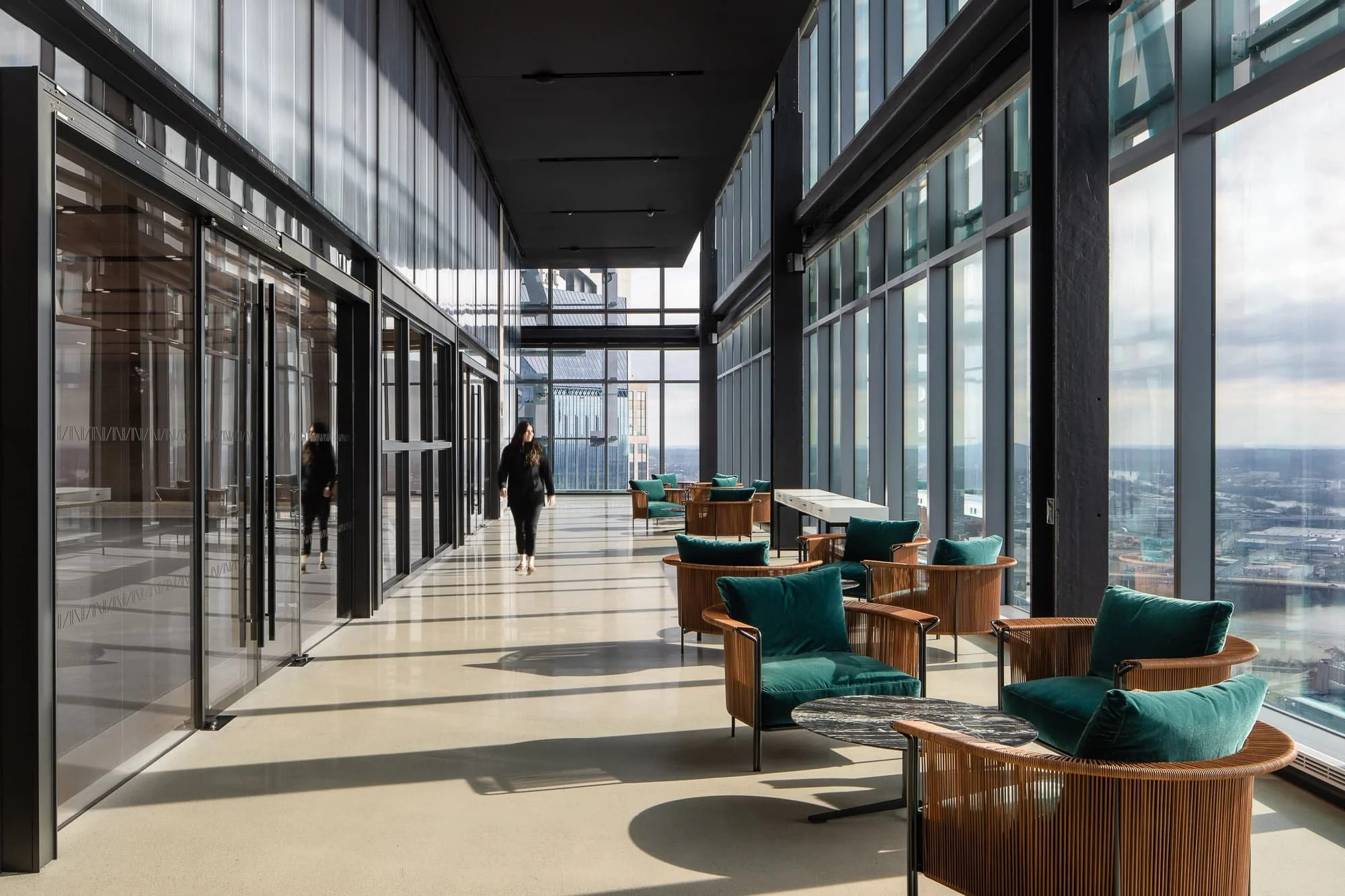 Sunlit corporate office lobby at Alliance Bernstein Nashville with floor-to-ceiling glass, city views, and a wood accent wall