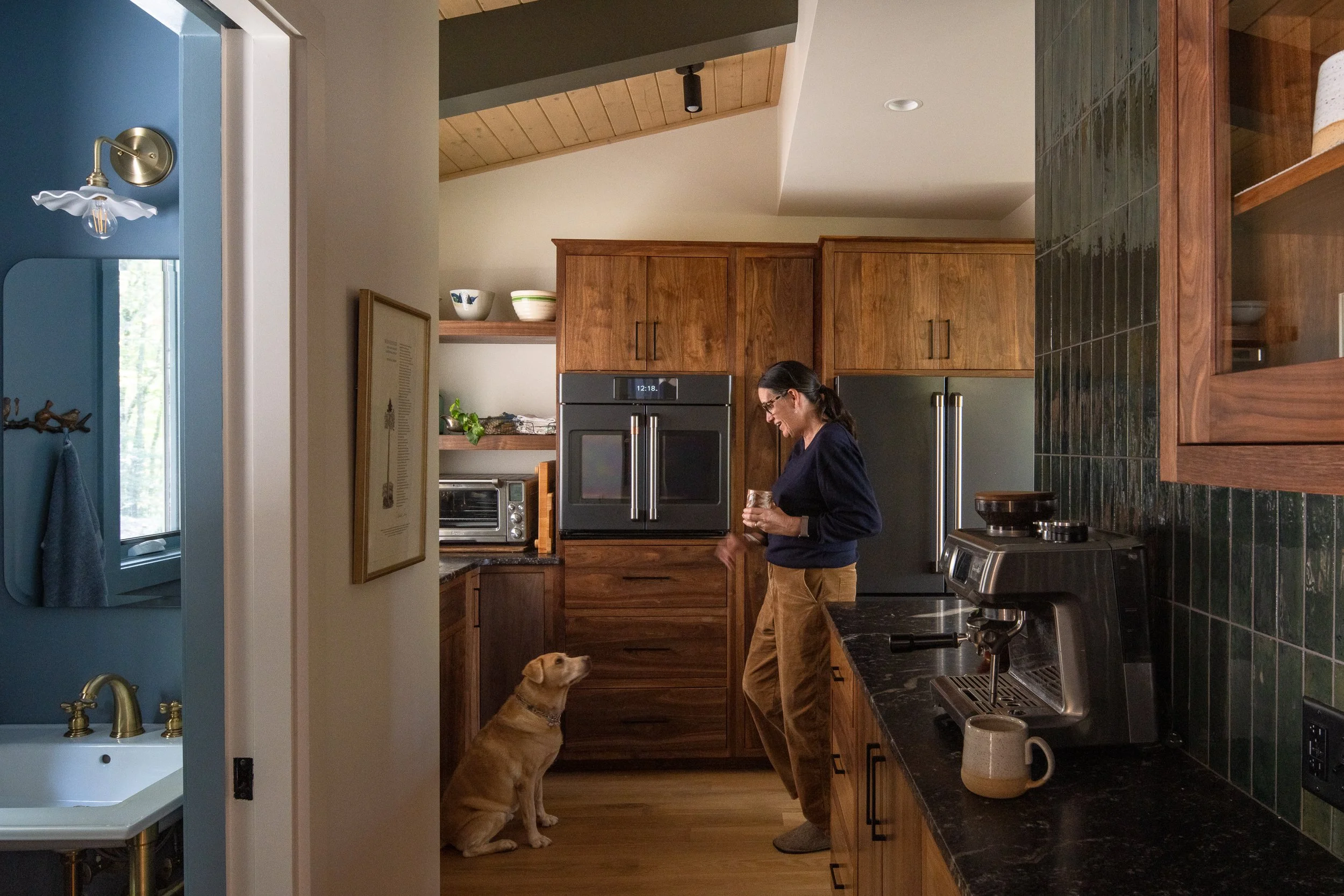Client standing in the kitchen while the dog sits nearby waiting for a treat.