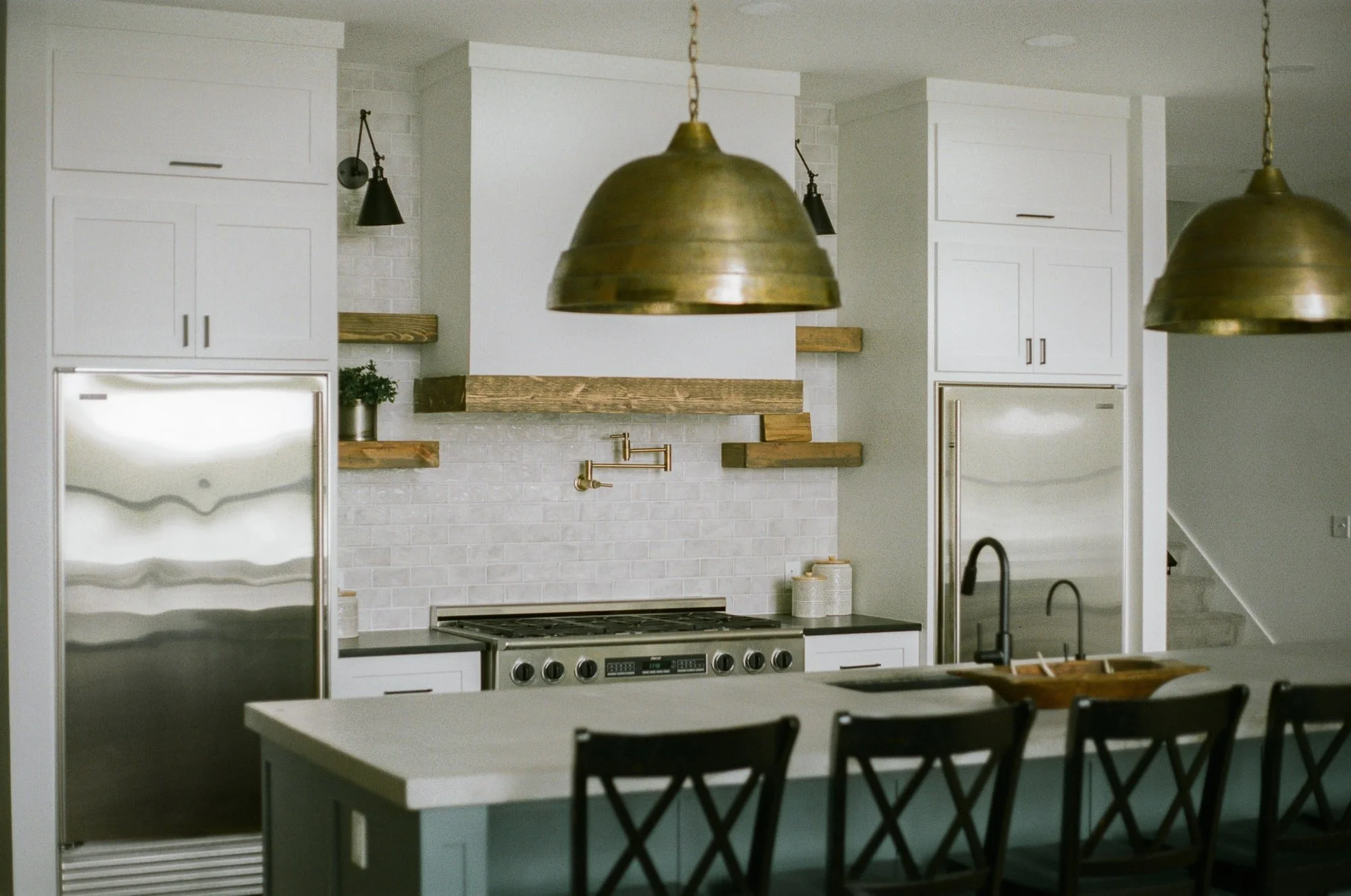 Kitchen island with brass pendant lights overhead, photographed on film in natural morning light