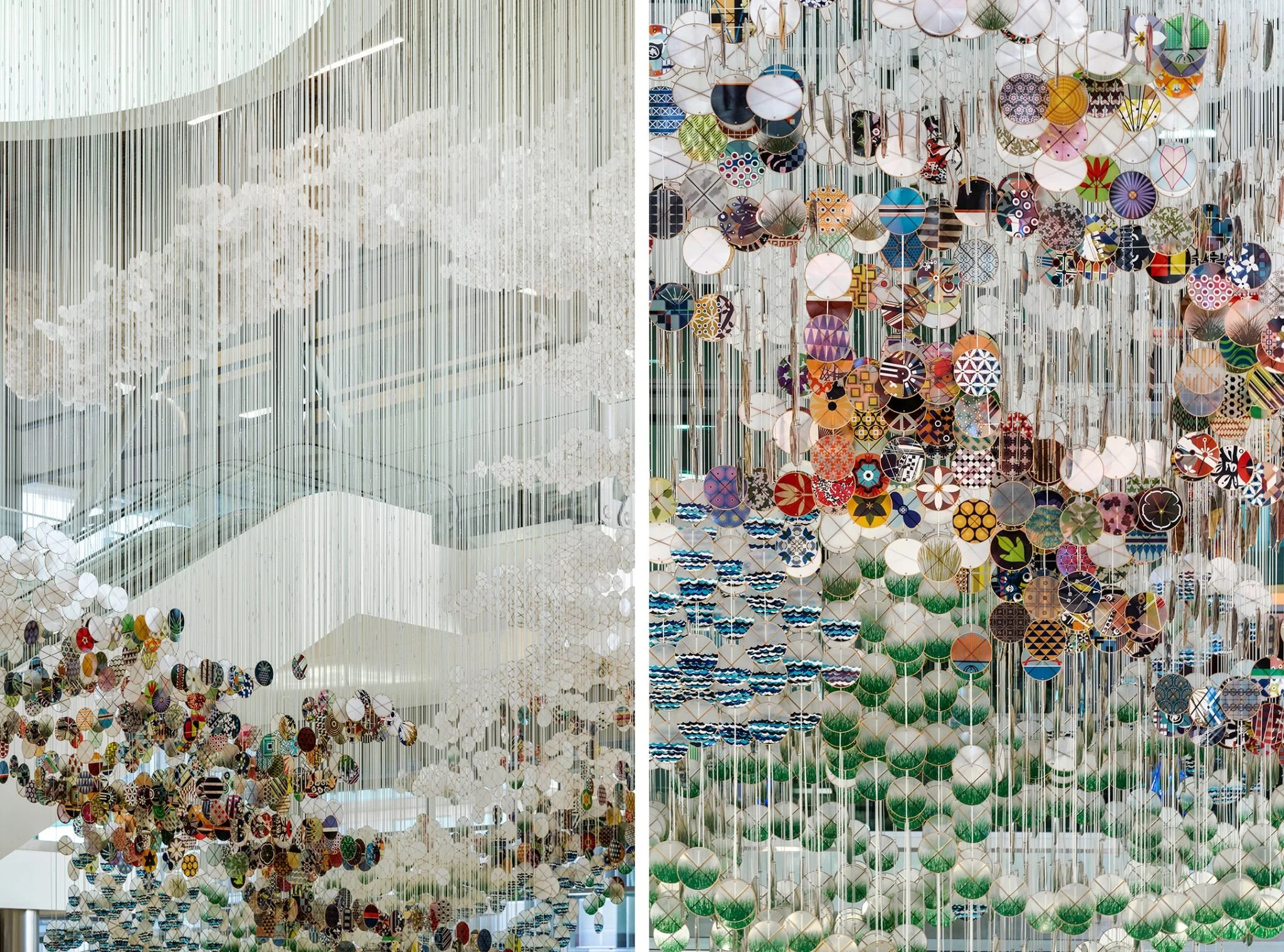 Detail of the suspended installation, showing white vertical strands and colorful circular elements arranged in layered patterns.