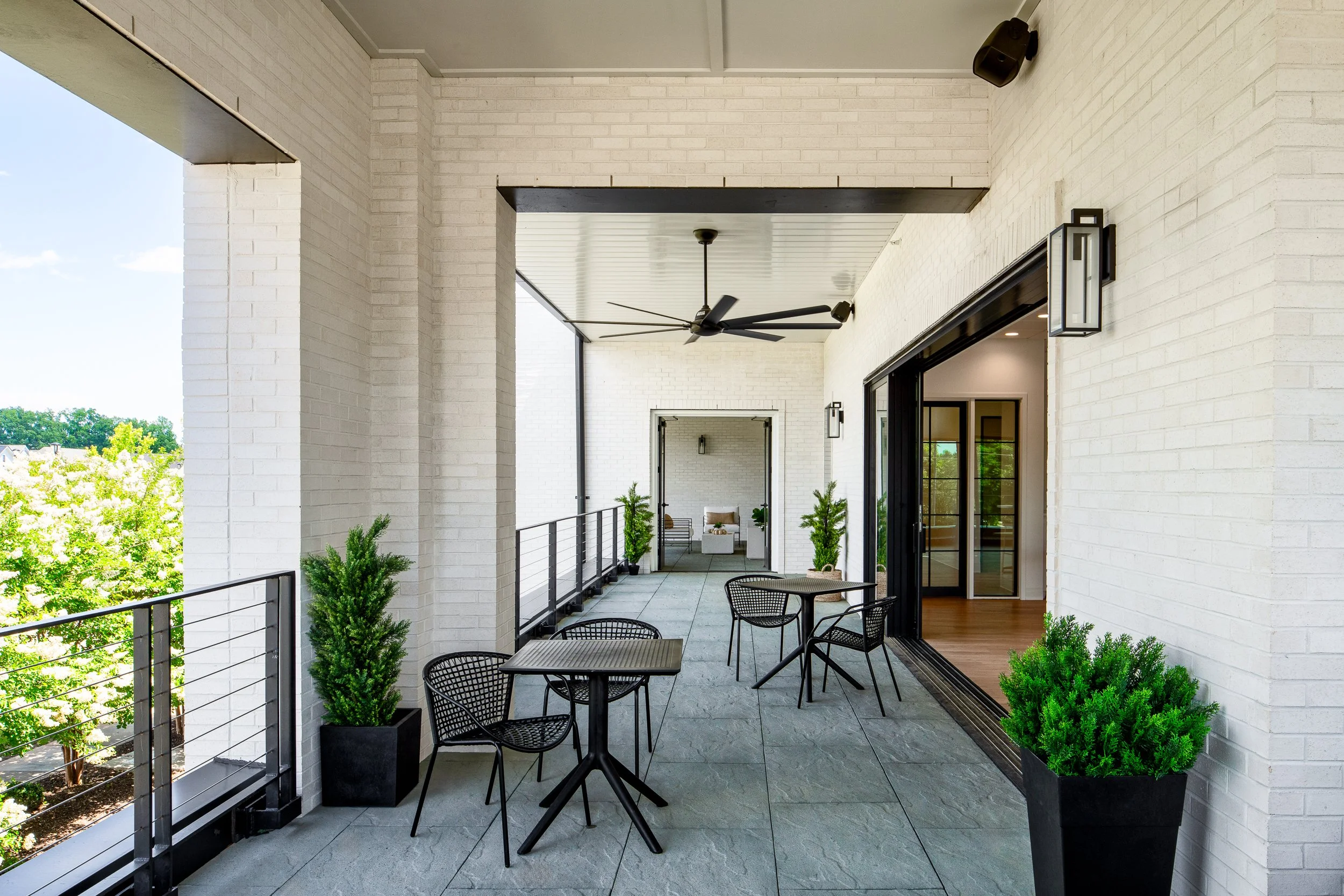 Modern covered patio with seating and a sleek black ceiling fan.