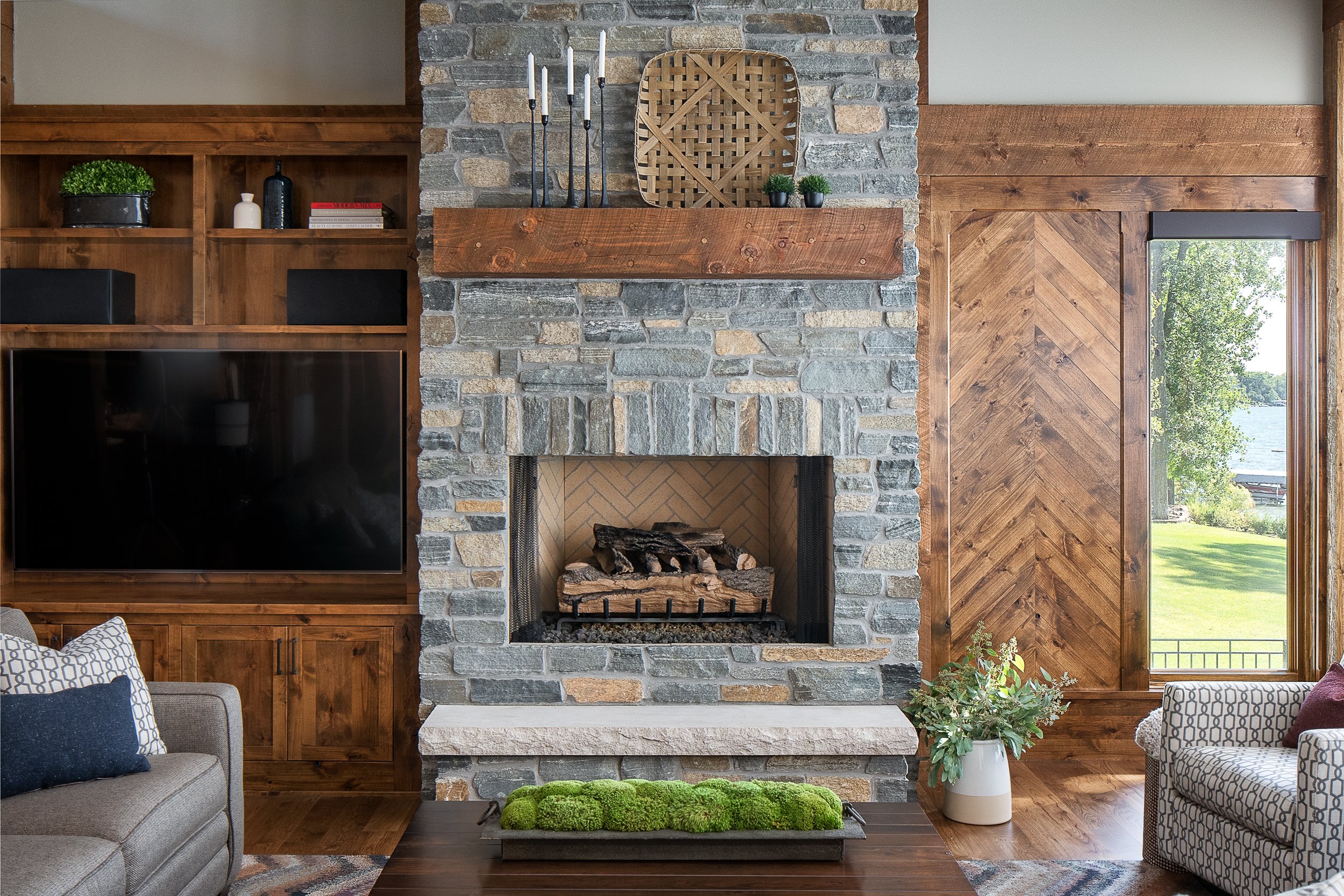 Stone fireplace with wood mantel flanked by built-in shelves.