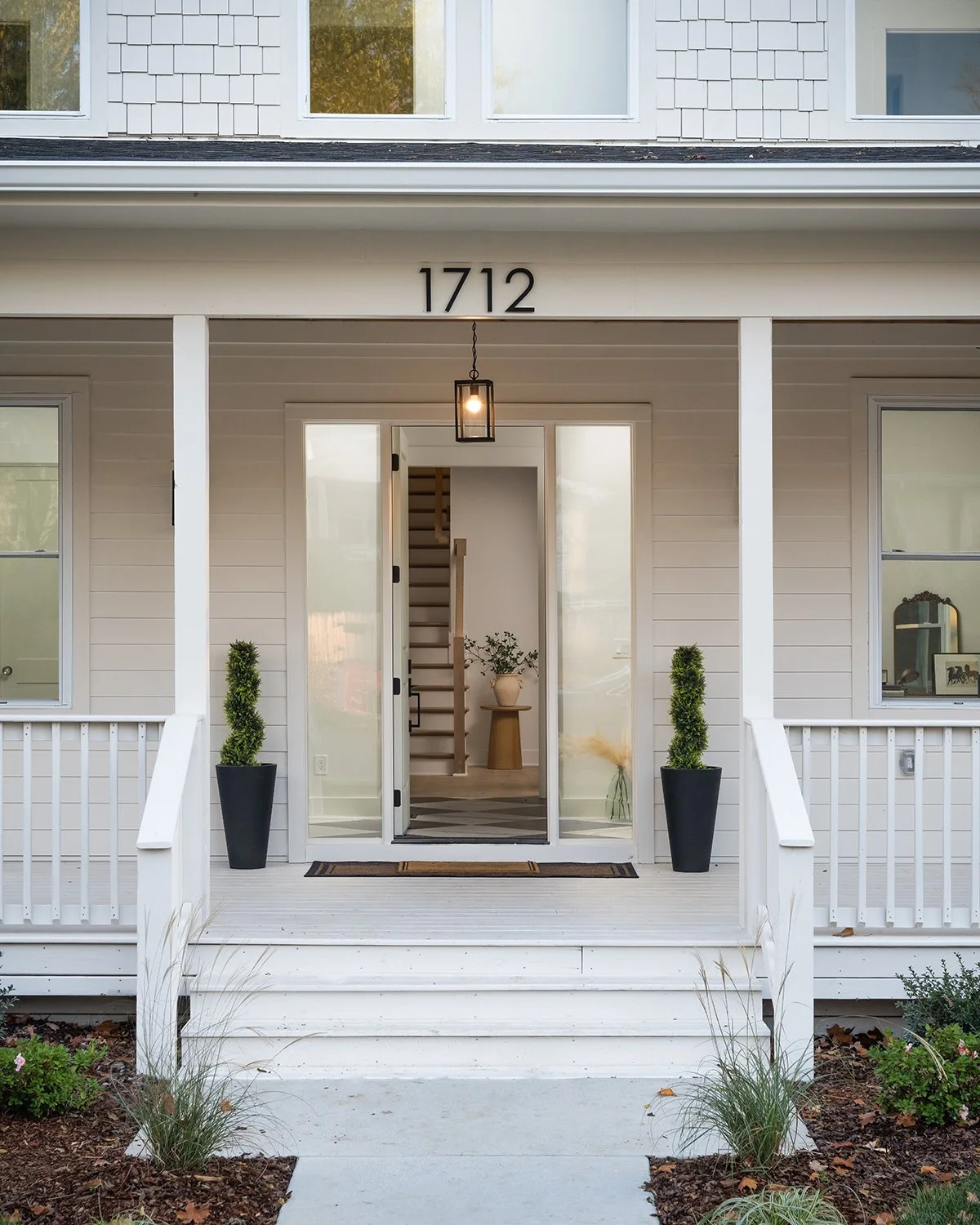 Front porch with welcoming design and white siding.