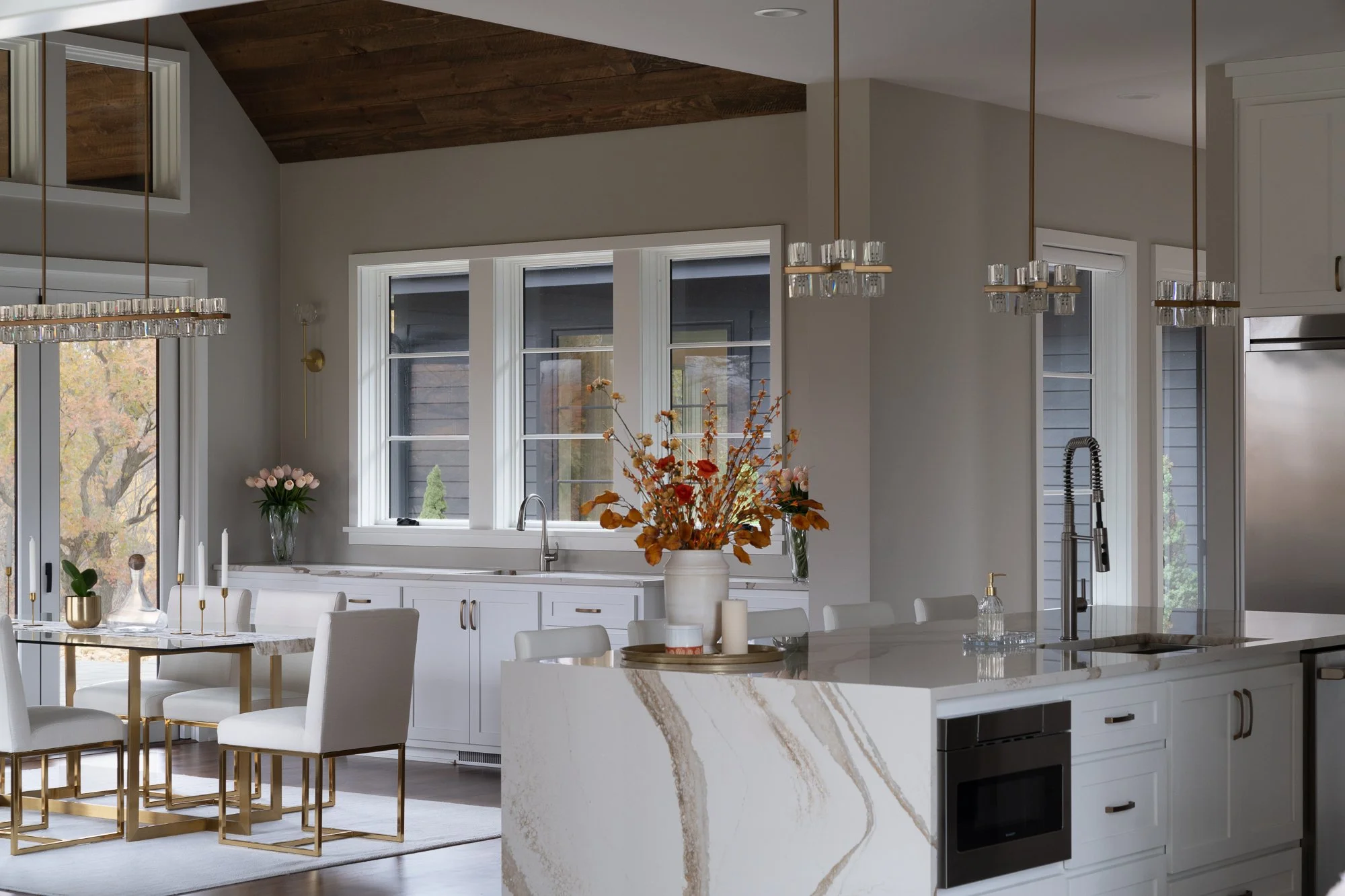 Modern kitchen with white cabinetry, a waterfall island, and gold accents.