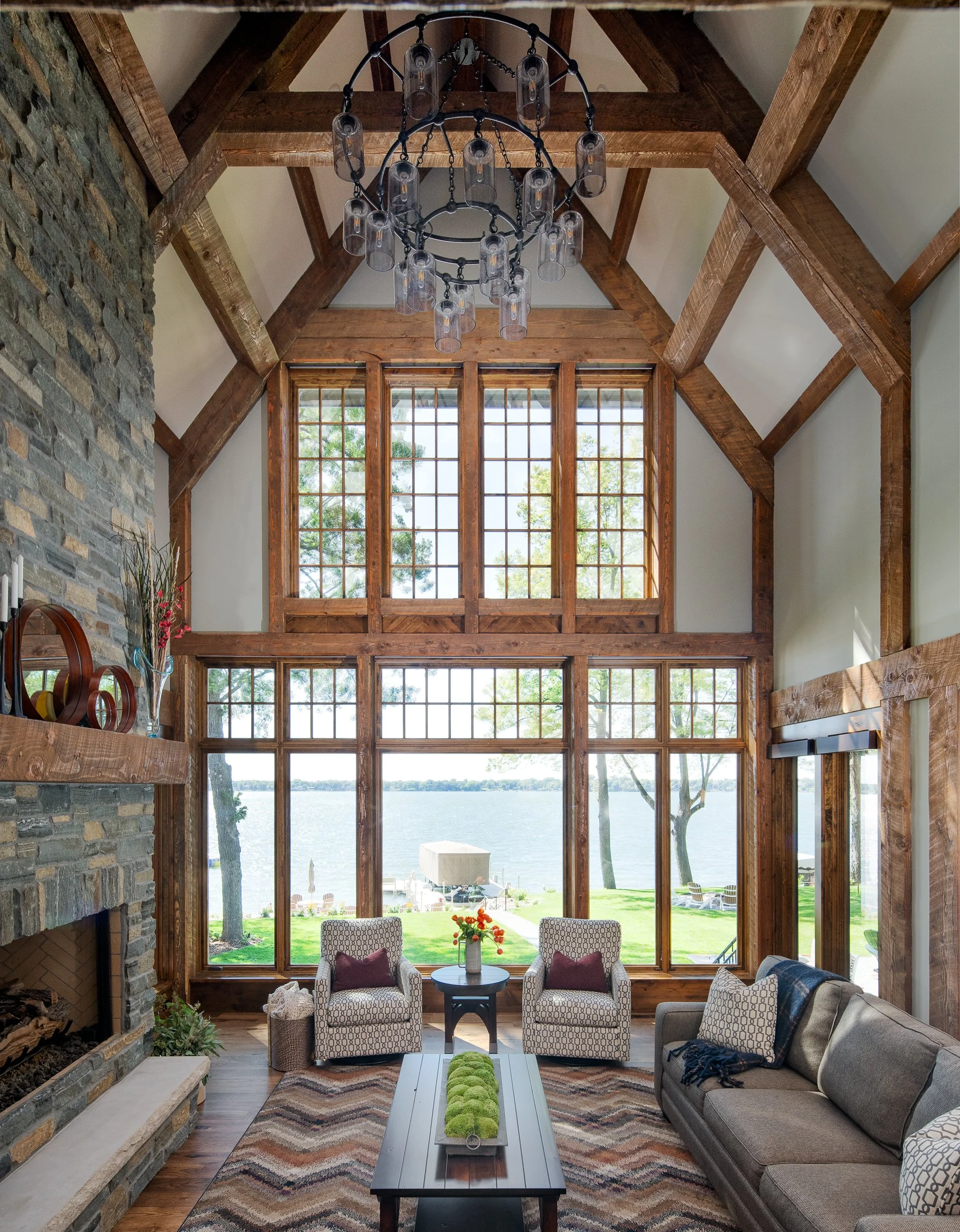 Living room with tall timber ceiling and lake view through windows.