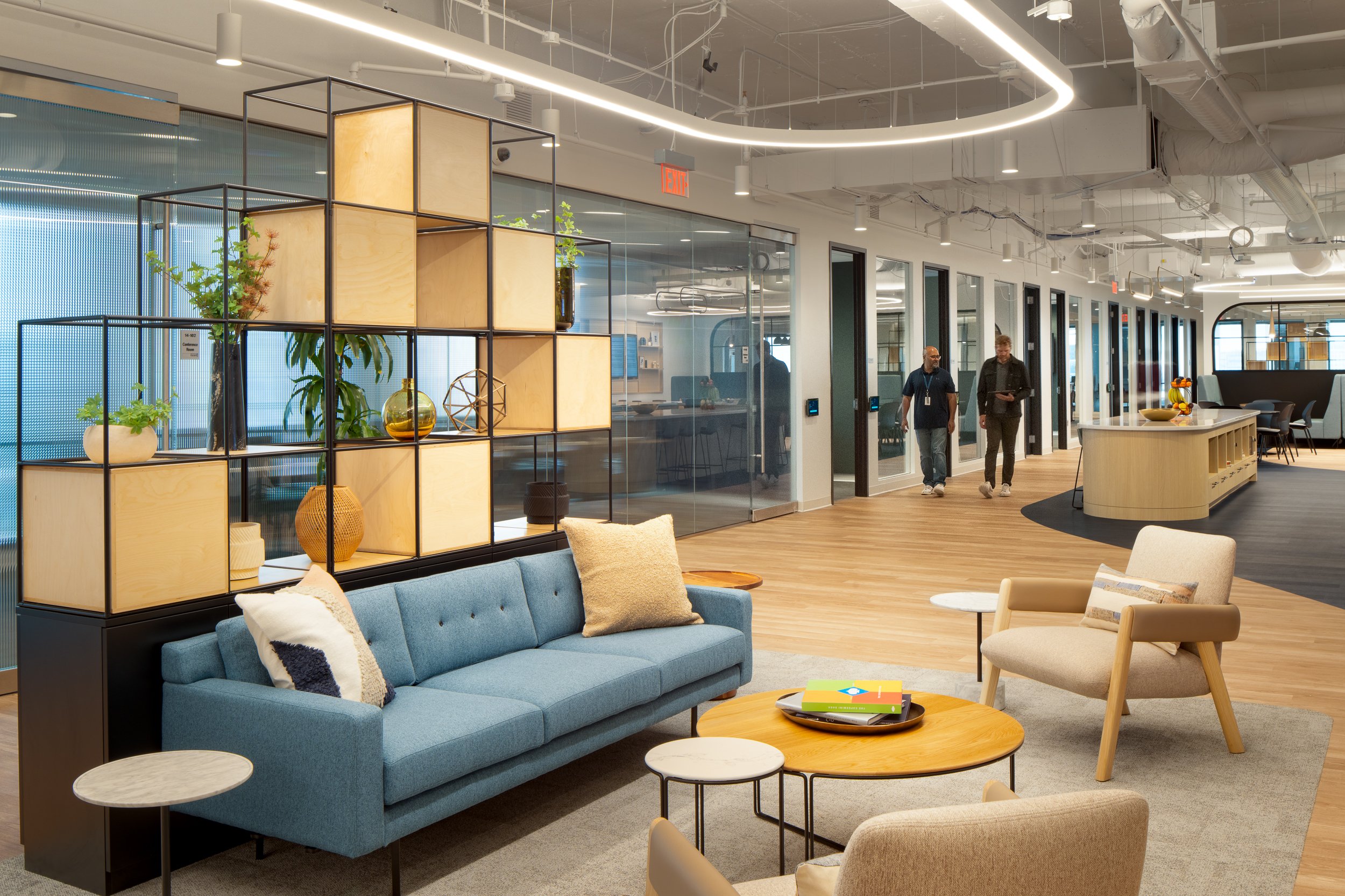 Modern office lounge and hallway in Atlanta with soft seating, warm lighting, and an open corridor beyond