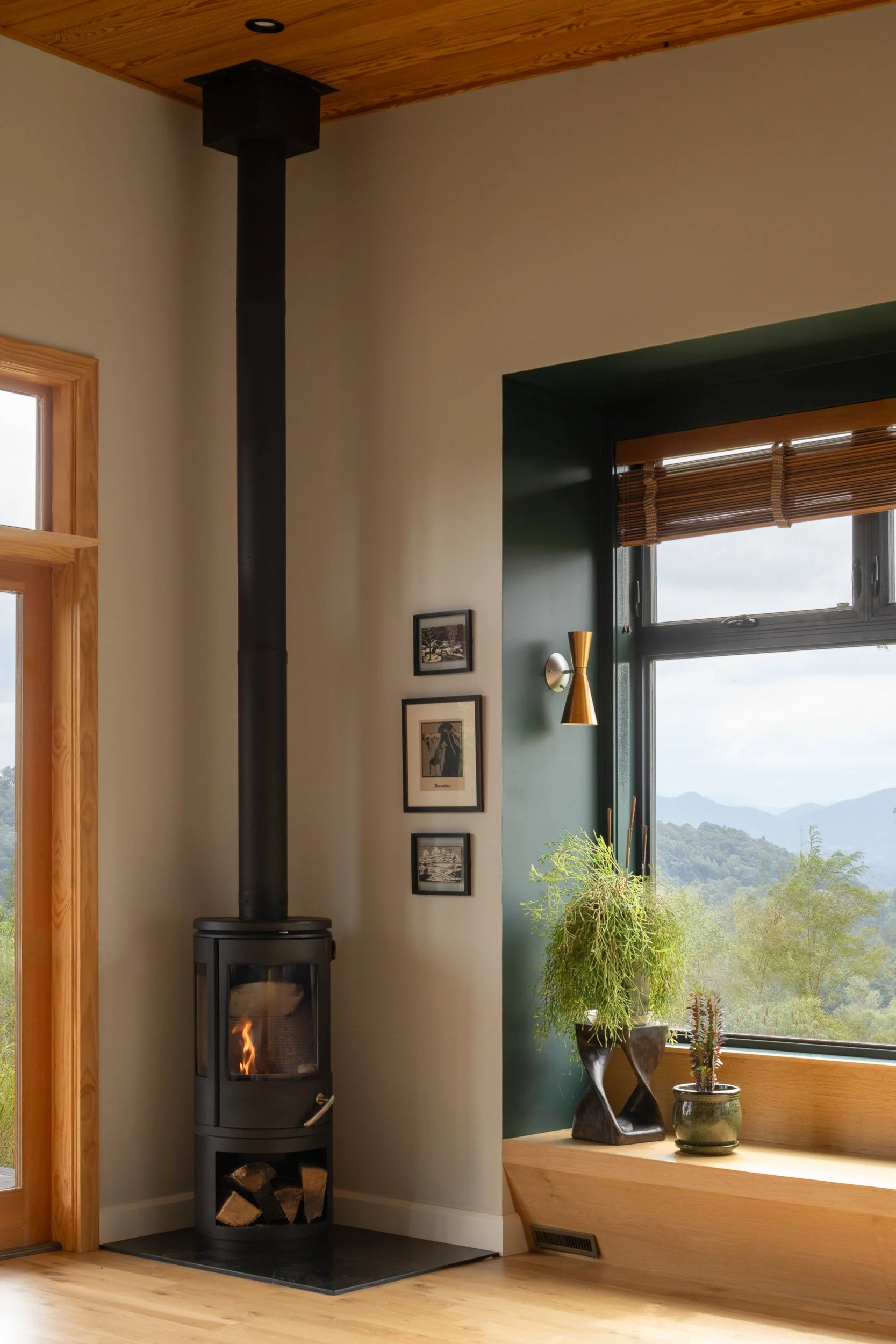 Modern wood-burning stove in a living space with a scenic view.